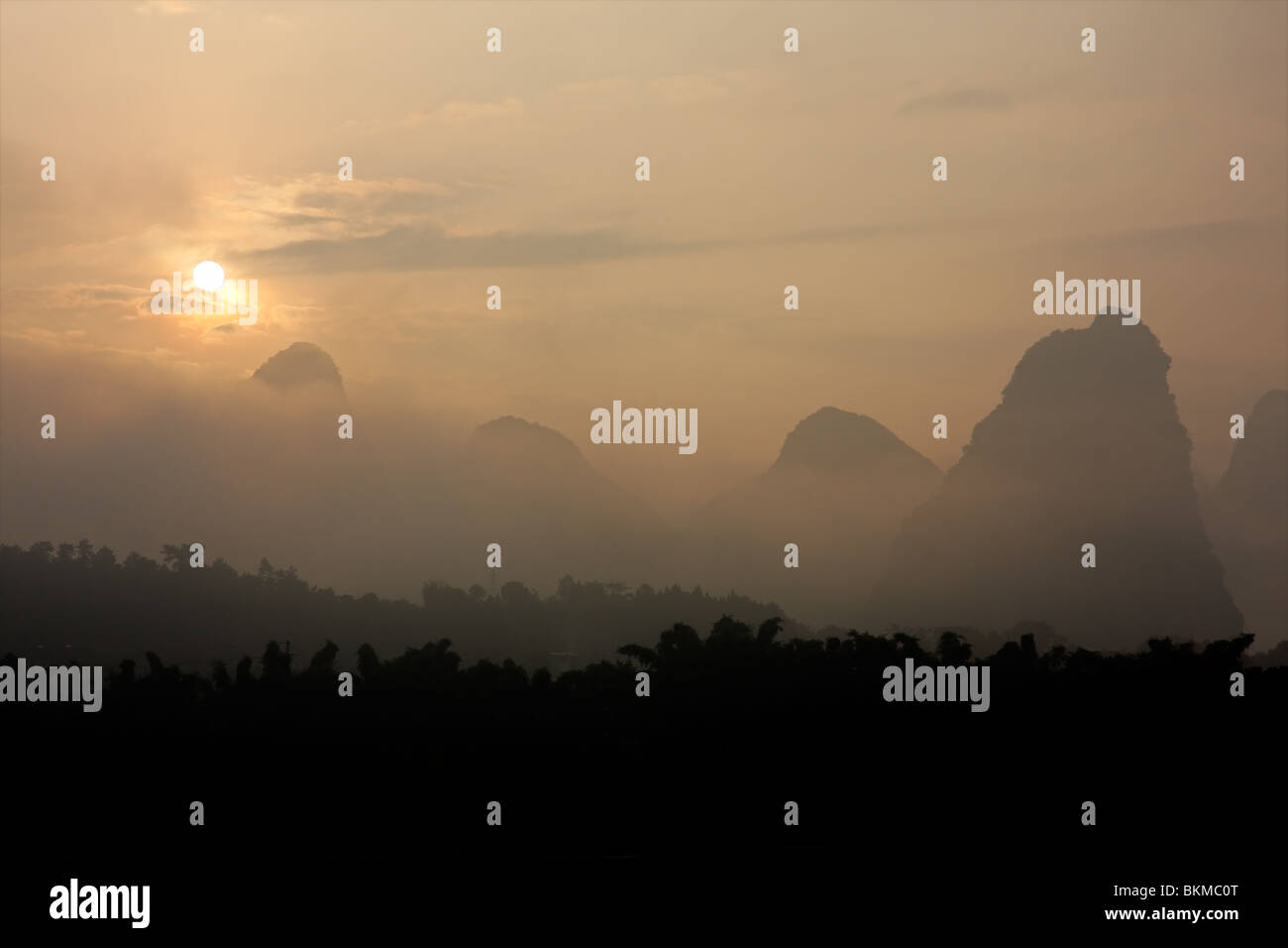 Distinctive limestone hills in mist at sunrise near Yangshuo, Guangxi region, China Stock Photo