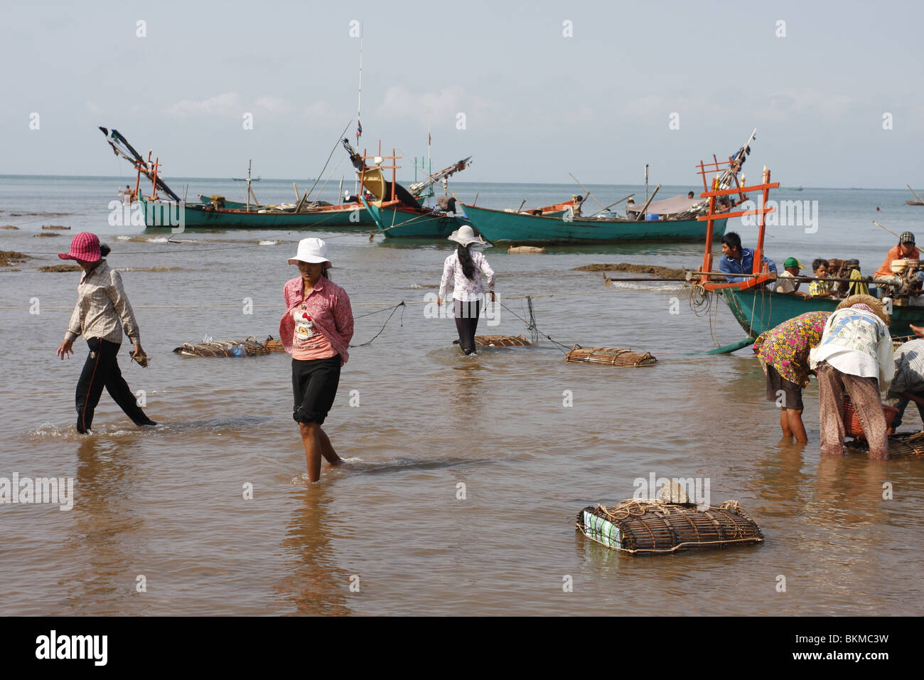 Early in the morning, long- tail fishing boats lie moored off the busy crab market in Kep, on Cambodia`s southeastern coast Stock Photo