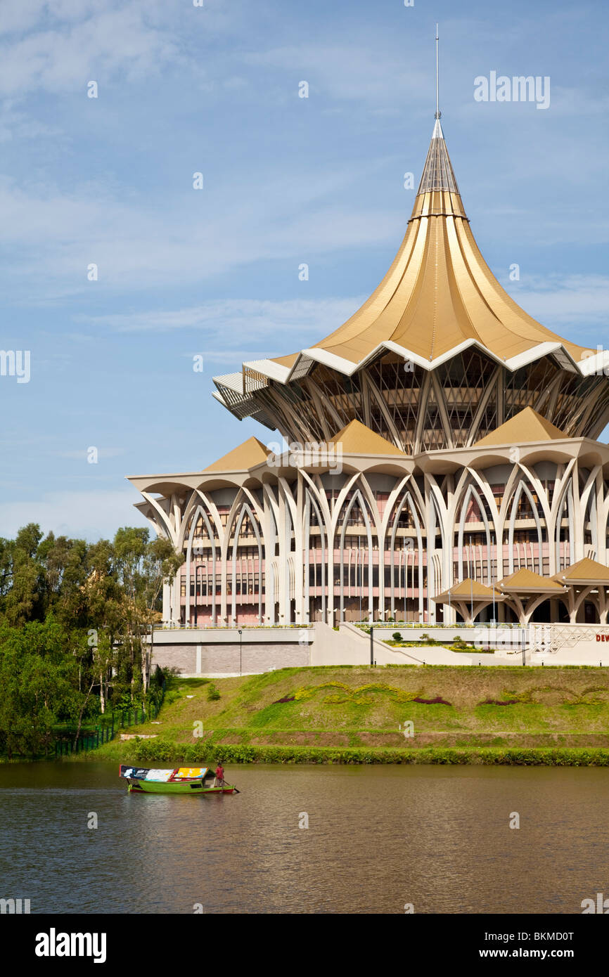 A tambang (water taxi) passes the Sarawak State Legislative Assembly Building. Kuching, Sarawak, Borneo, Malaysia. Stock Photo