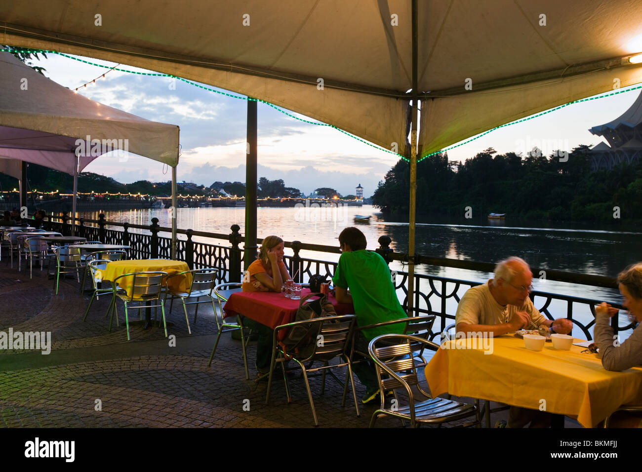 Tourists dining at cafe on the waterfront promenade.  Kuching, Sarawak, Borneo, Malaysia. Stock Photo