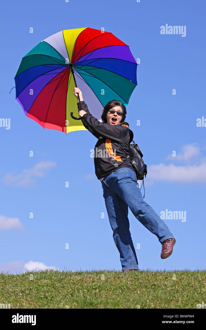 A Woman Pretending To Be Blown Away By The Wind With Her Big Umbrella 