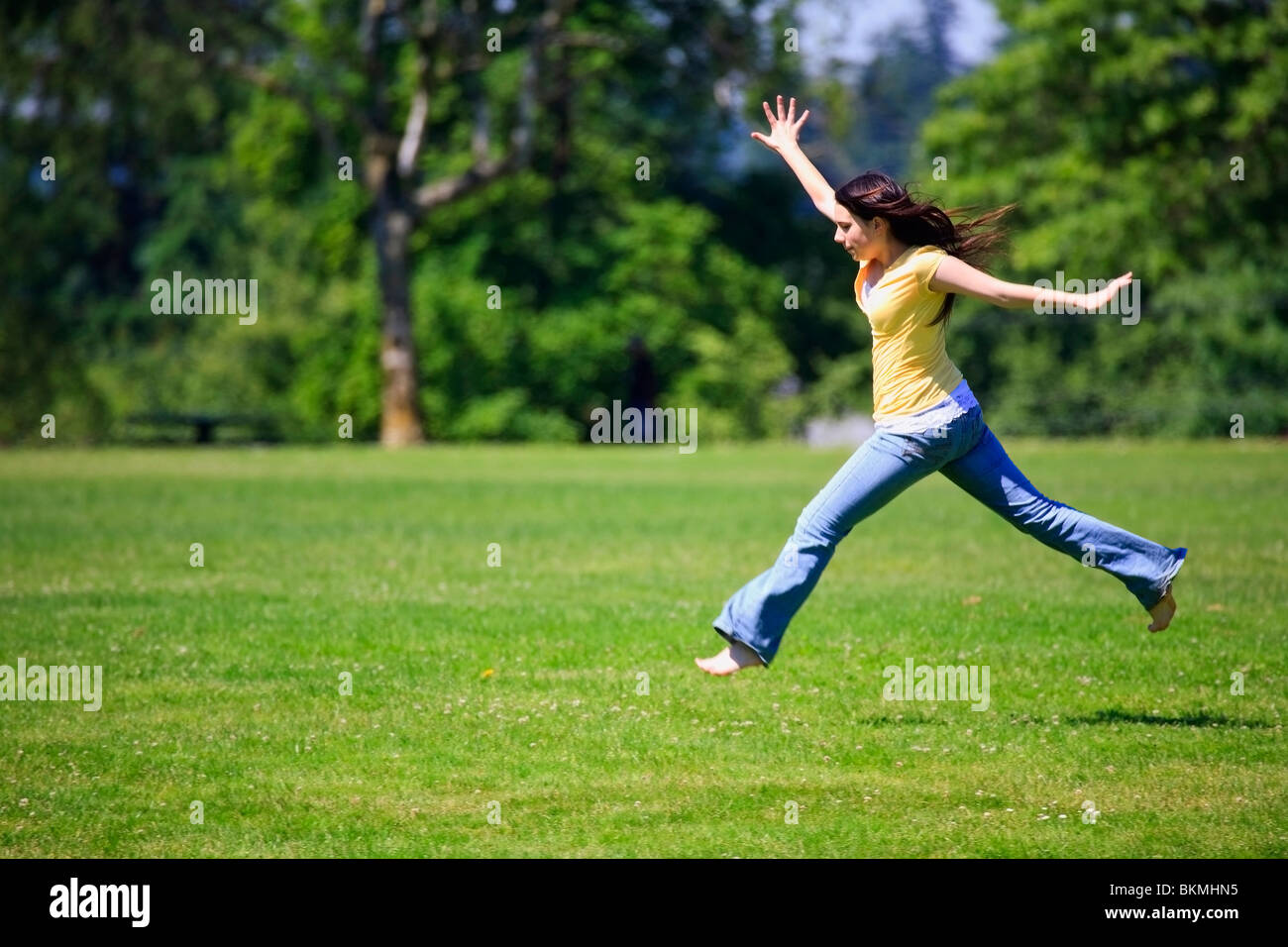 A Teenage Girl Leaping Across The Grass Stock Photo Alamy
