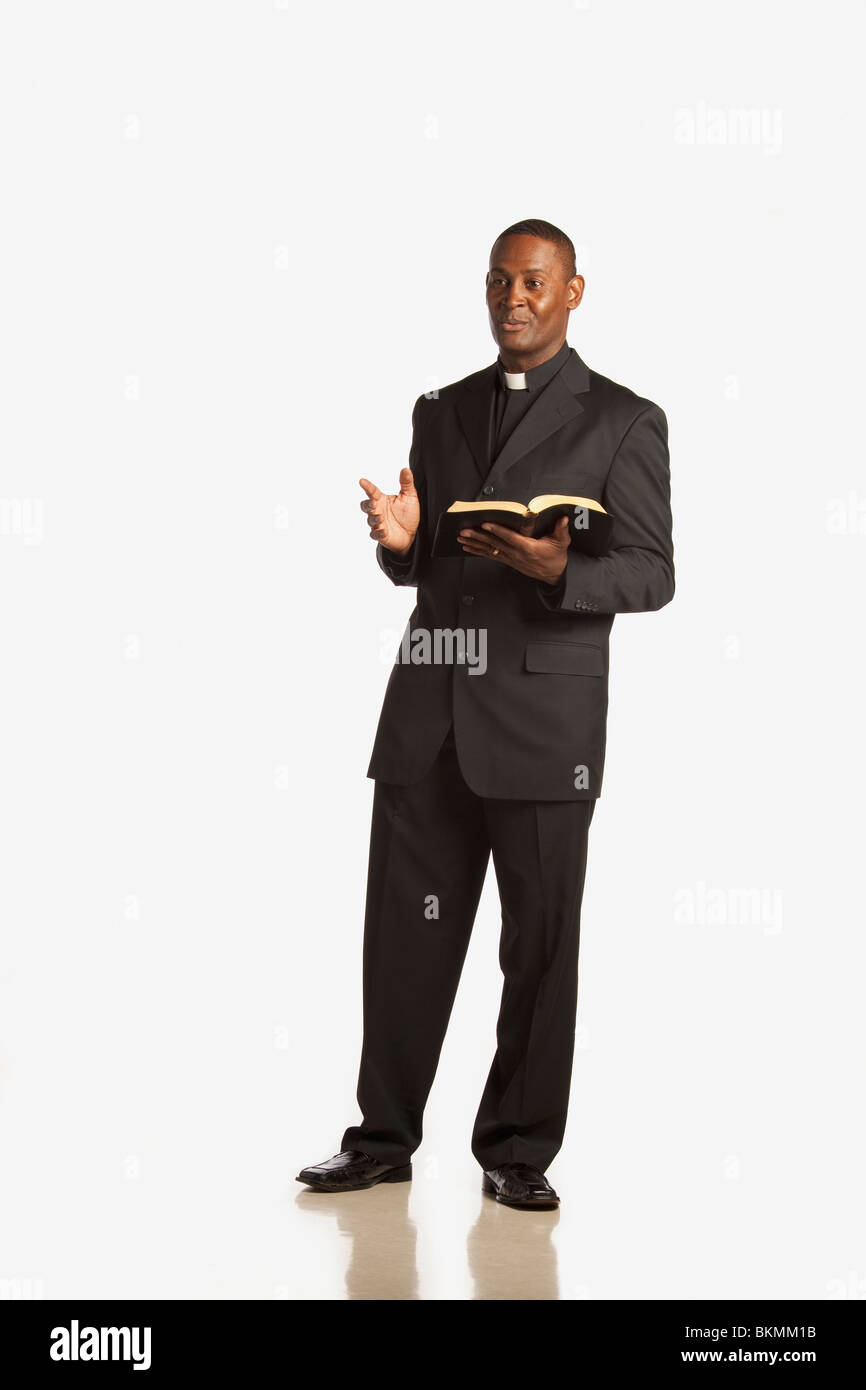 A Man Wearing A Clerical Collar And Preaching From The Bible Stock Photo