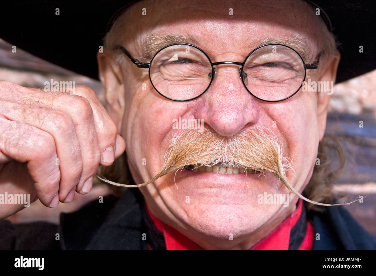 Local man dresses as town sheriff in Placerville, California, USA. Here he pretends to be a villain, twirling his moustache. Stock Photo