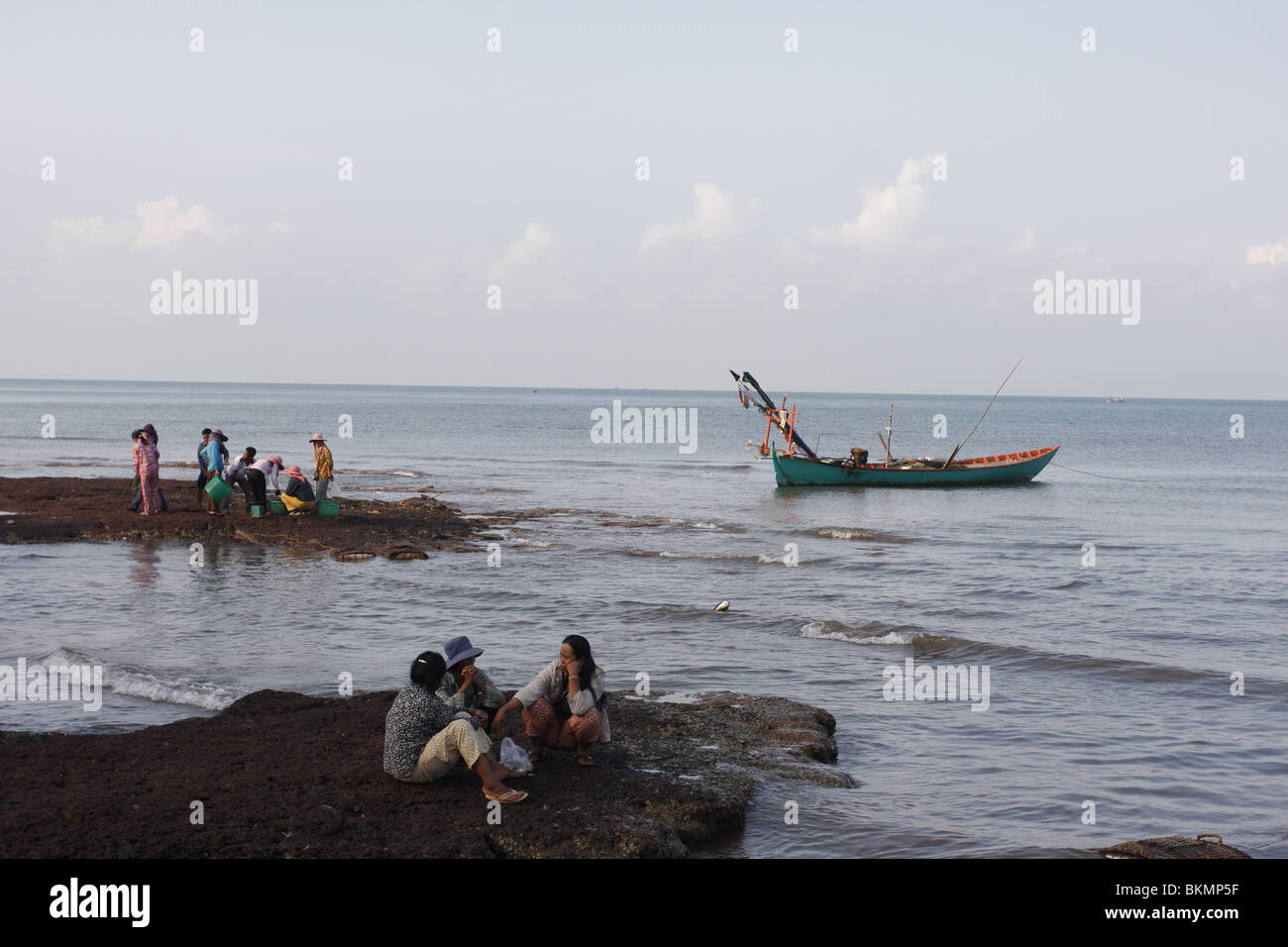 Early in the morning, long- tail fishing boats lie moored off the busy crab market in Kep, on Cambodia`s southeastern coast Stock Photo