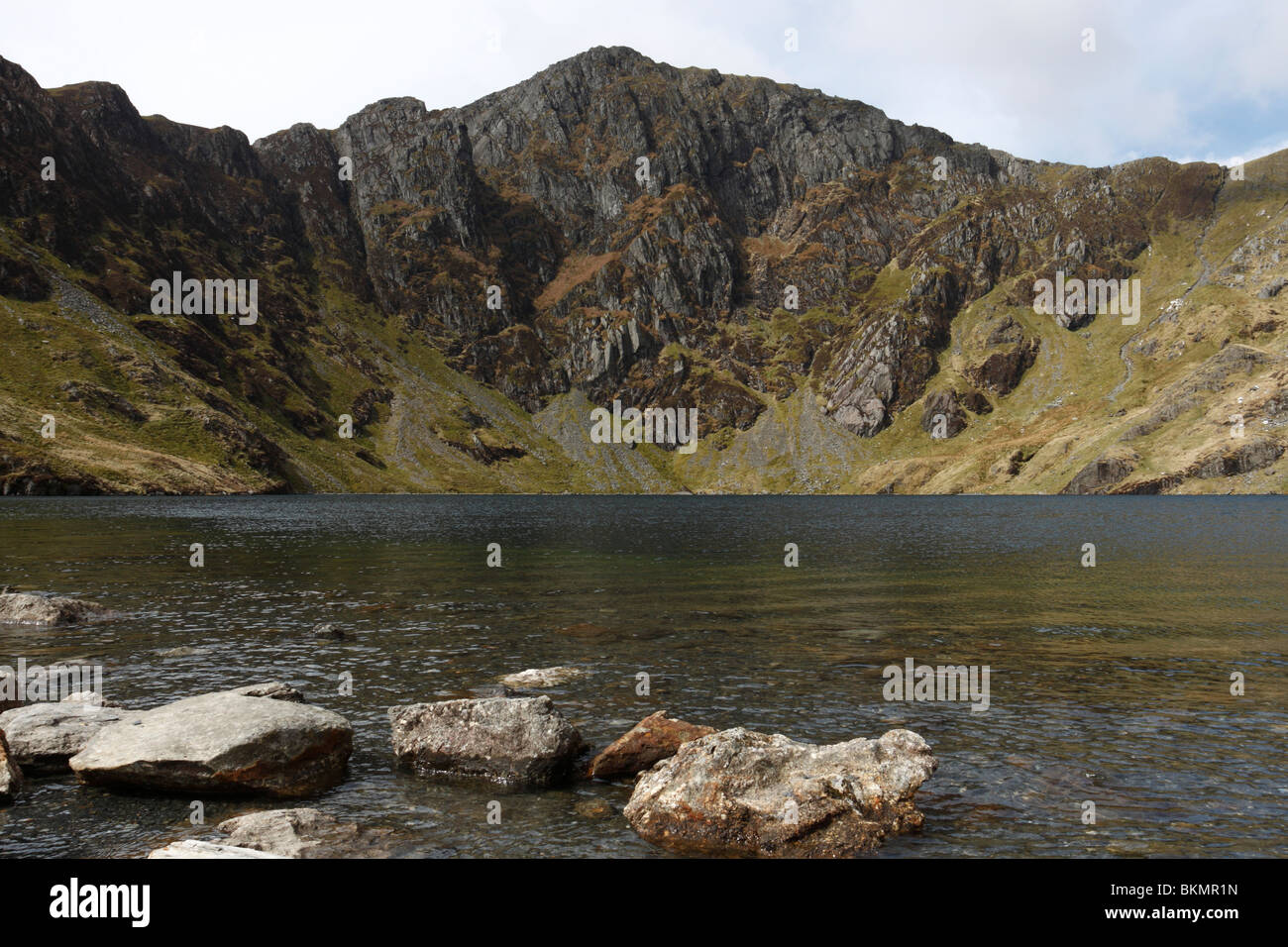 The lake of Llyn Cau nestled beneath the great cliffs of Craig Cau on the mountain of Cadair Idris in Snowdonia, North Wales Stock Photo