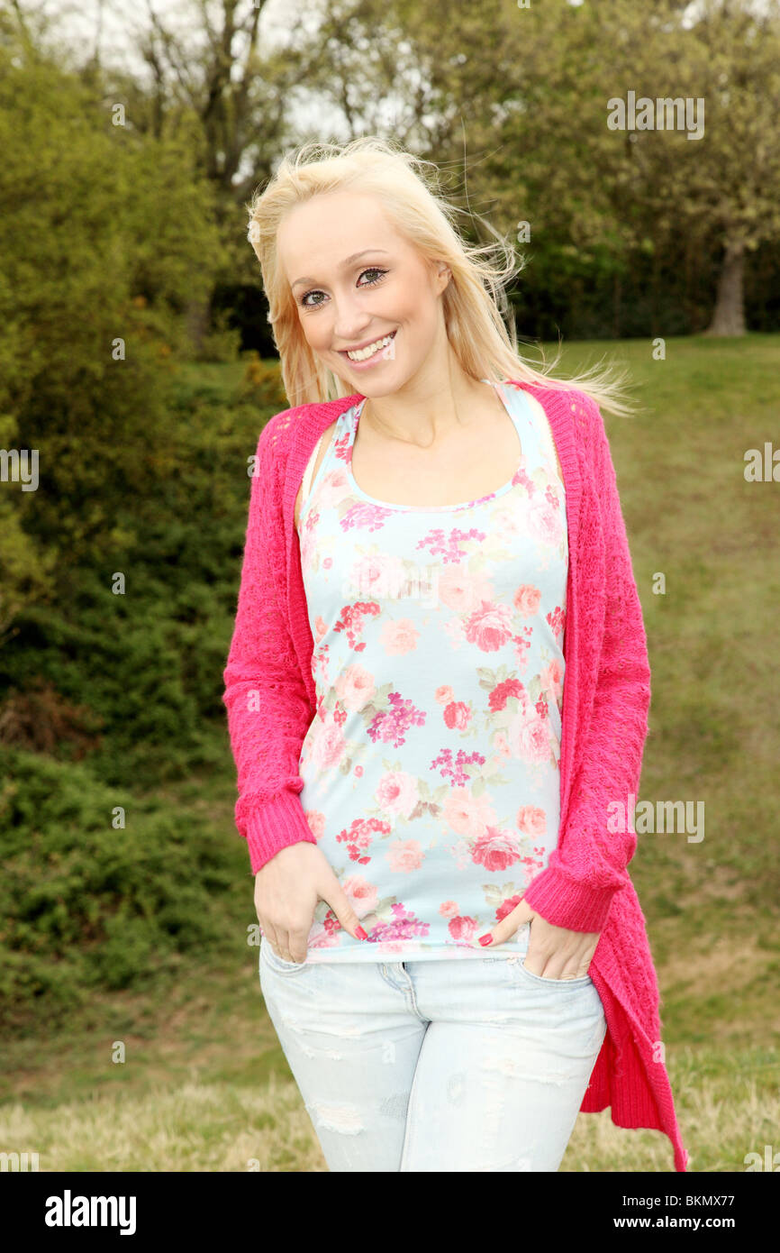 Three quarter length portrait of an attractive young blonde female looking to camera smiling Stock Photo