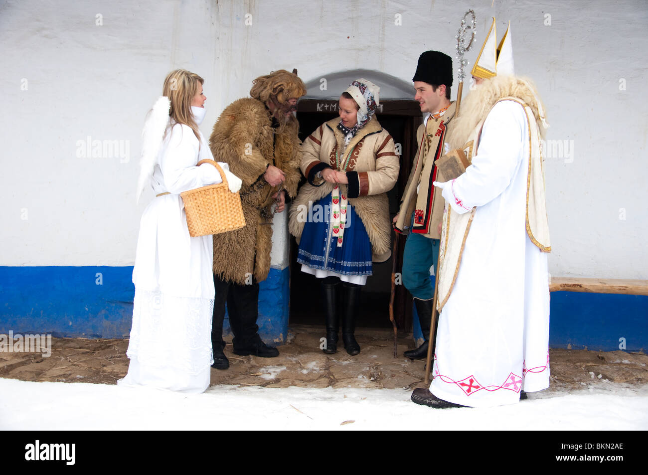 Saint Miculas, angel and devil are visiting rural house and people in folk costume about Christmas Stock Photo
