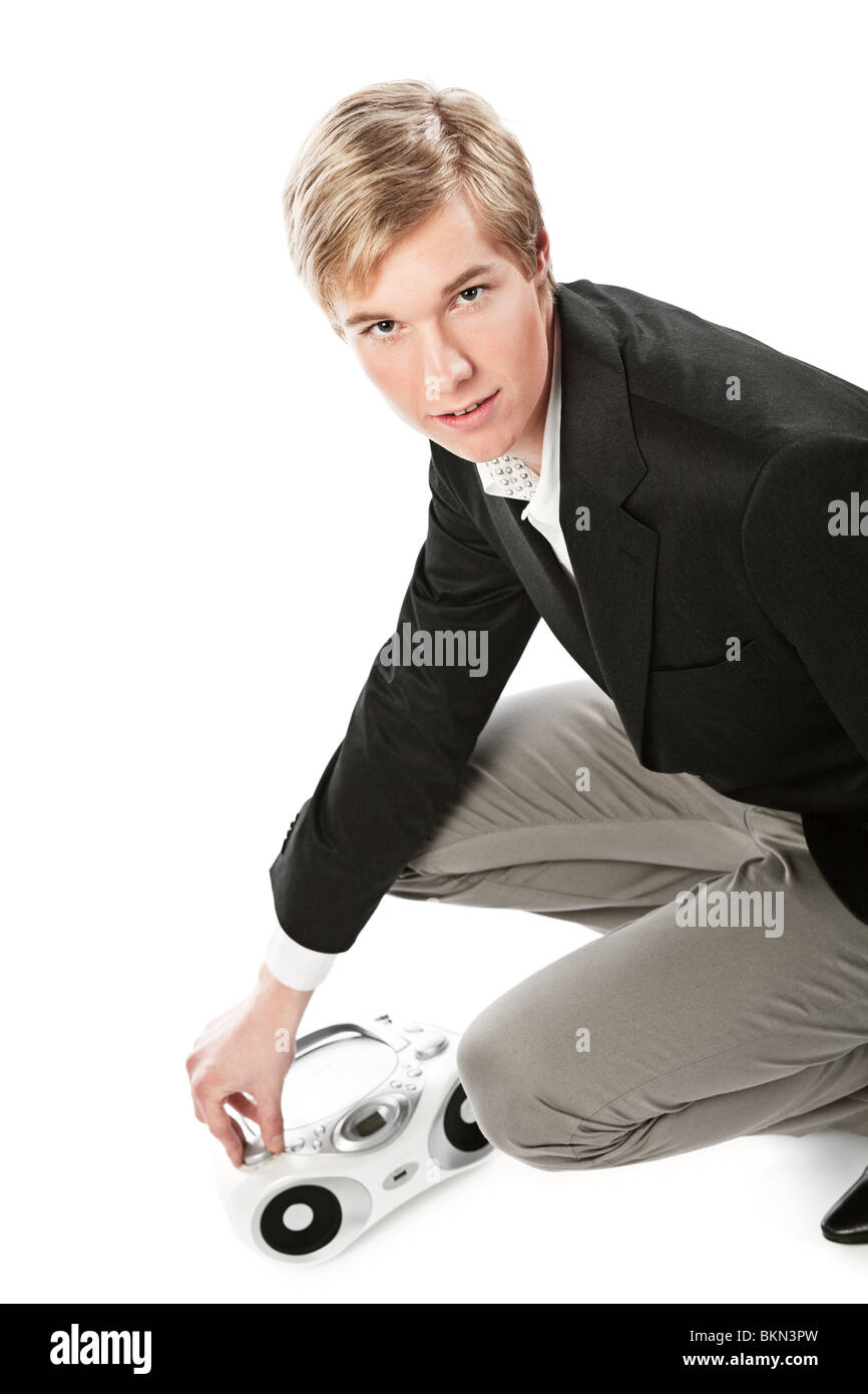Young blond handsome man changing sound volume at boombox; isolated on white Stock Photo
