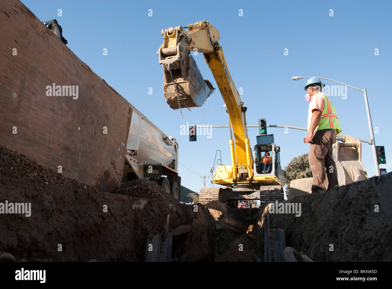 A sewer pipe is placed as a pipeline by a crane. Stock Photo