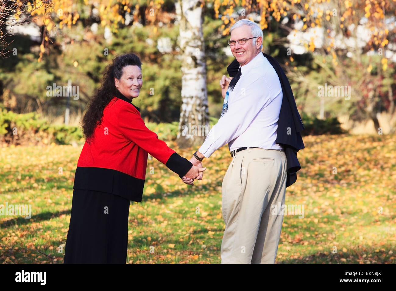 A Couple Holding Hands In The Park In Autumn Stock Photo - Alamy