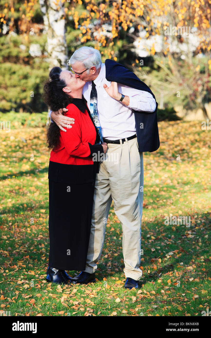 A Couple Kissing In The Park In Autumn Stock Photo - Alamy