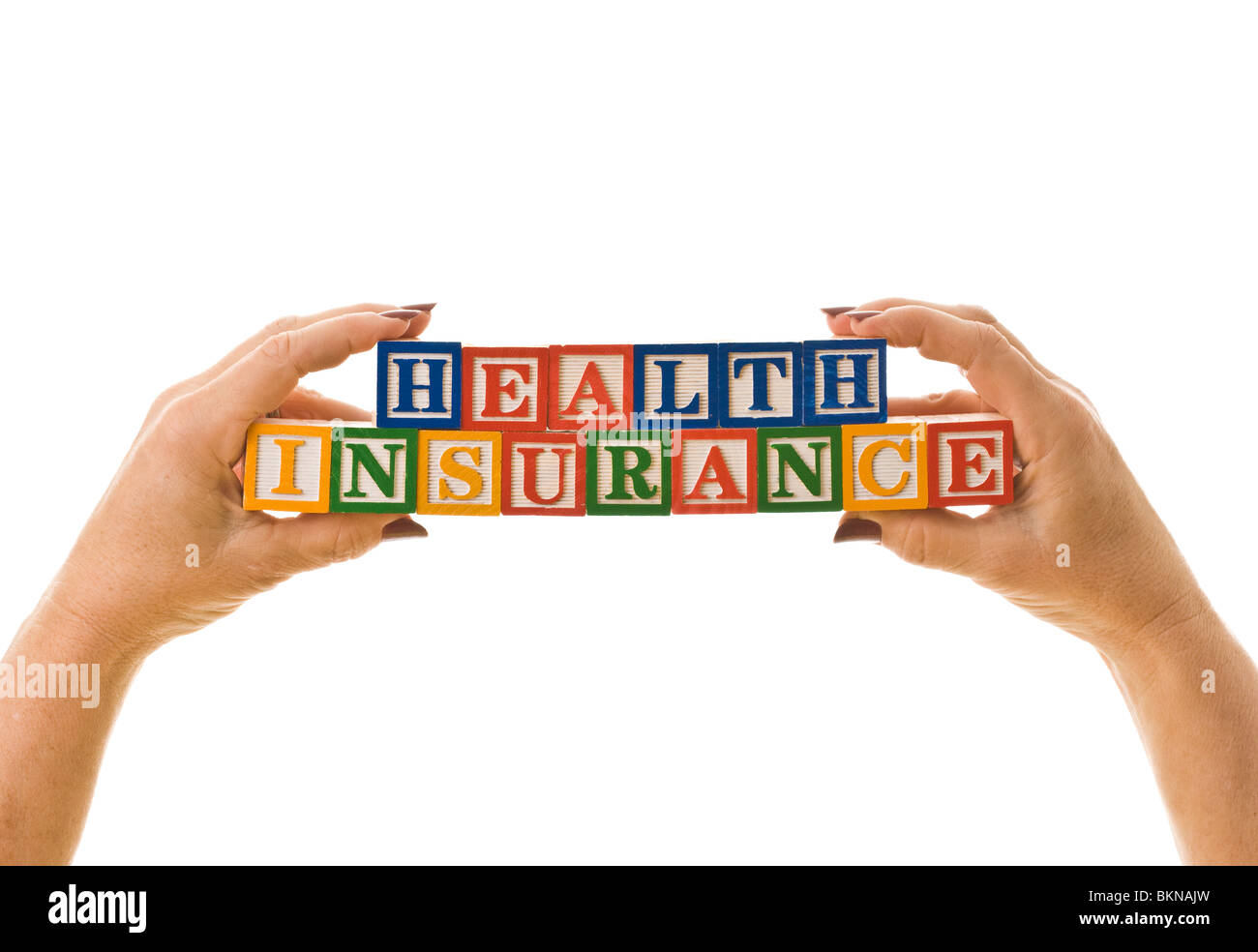 Getting your hands around healthcare. Woman holding children's blocks that spell 'HEALTH INSURANCE'. Stock Photo