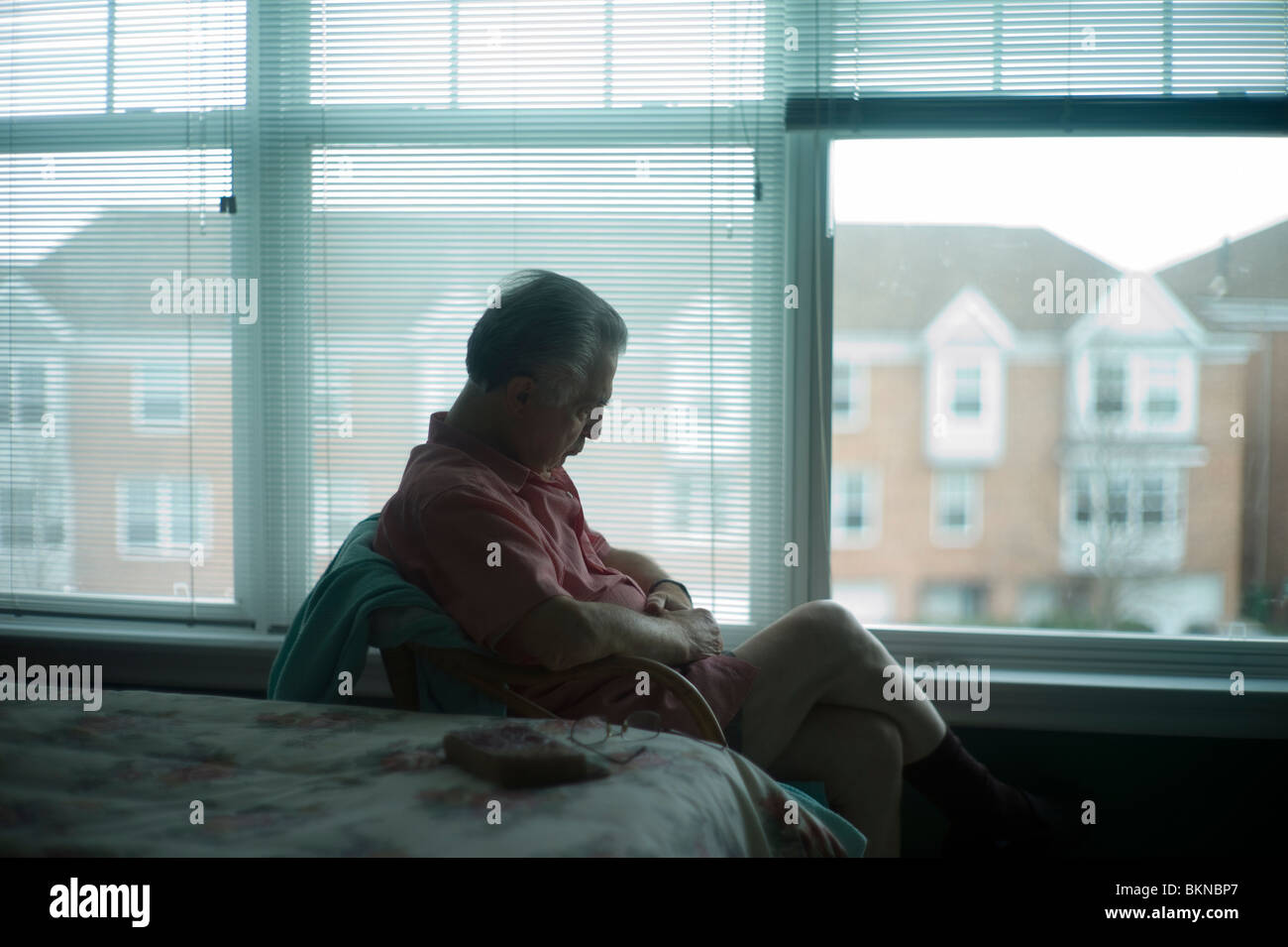Old man sleeps sitting up in chair by bedroom window Stock Photo Alamy
