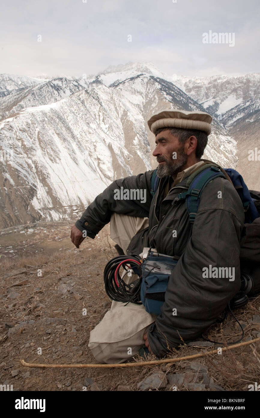 Guide with sound gear wearing traditional Pakol in the mountains of Chitral Stock Photo
