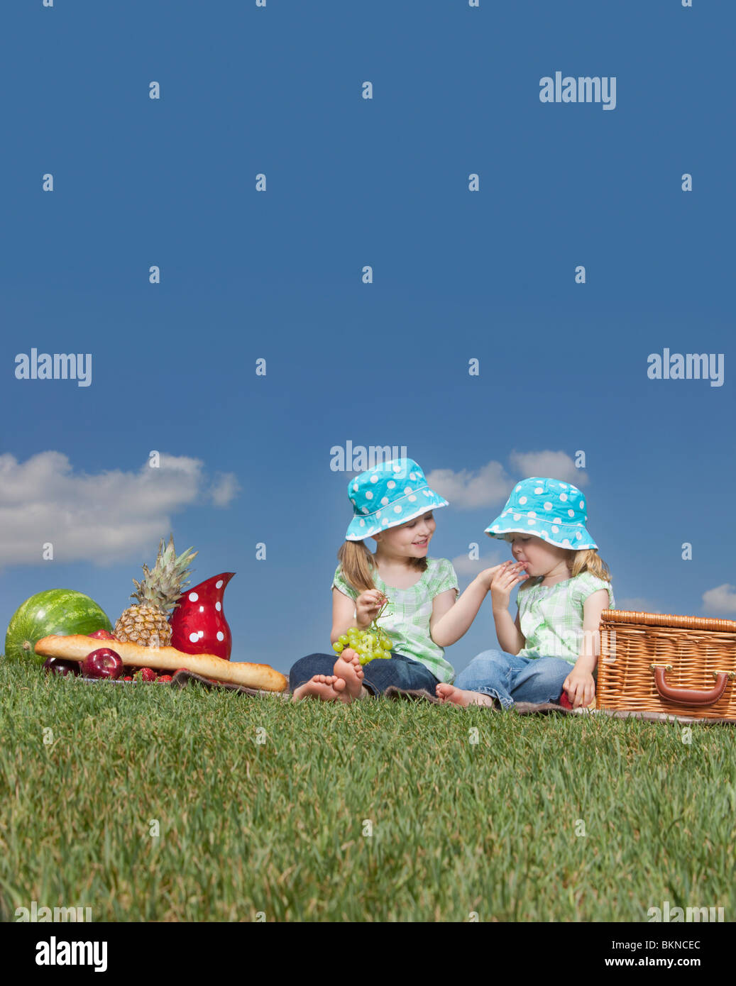 Two Young Girls Eating At A Picnic Stock Photo Alamy