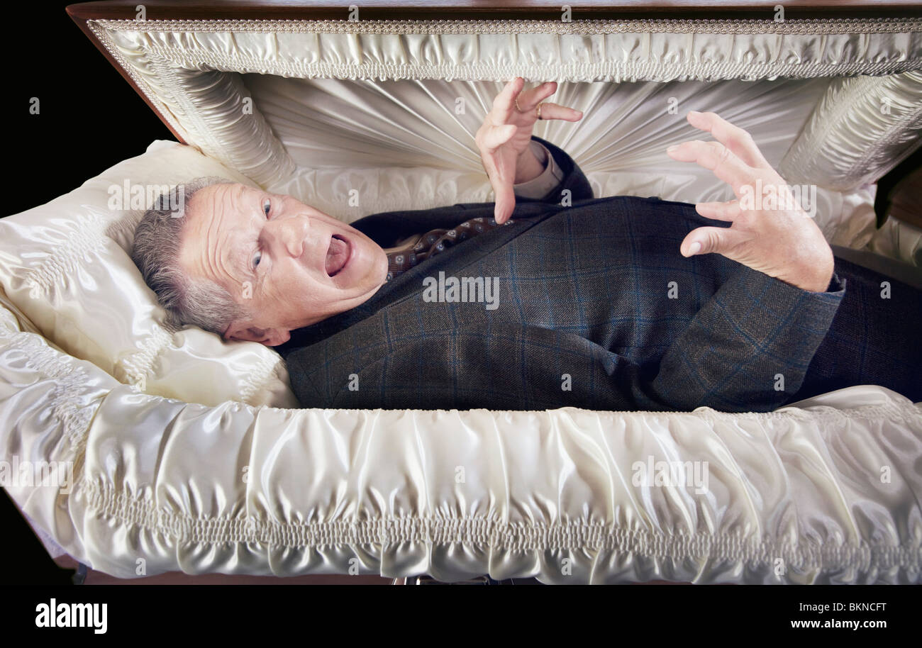 A Man Alive And Laying In A Coffin Stock Photo