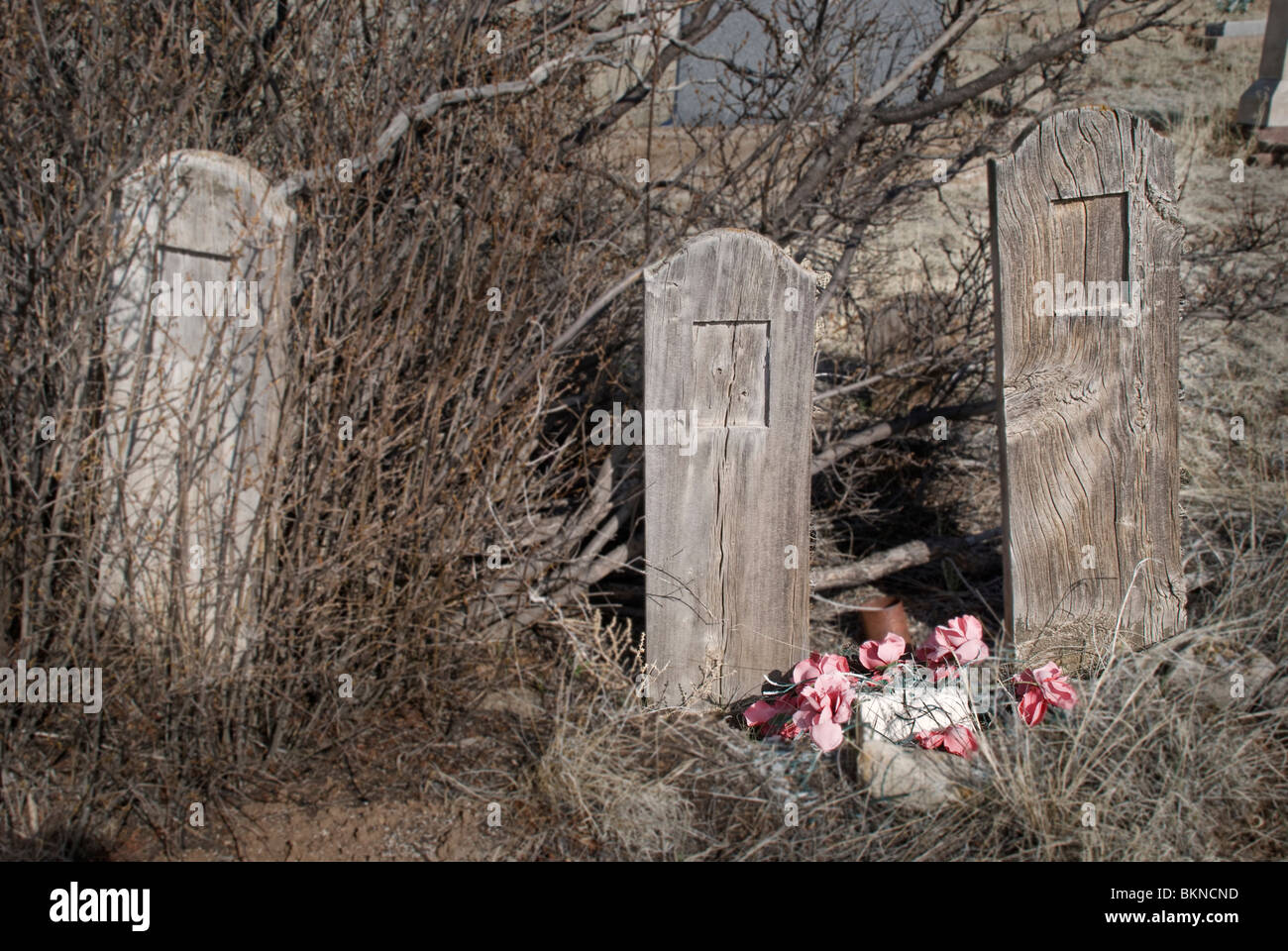 Three old cemetery markers mark unidentified grave sites in a