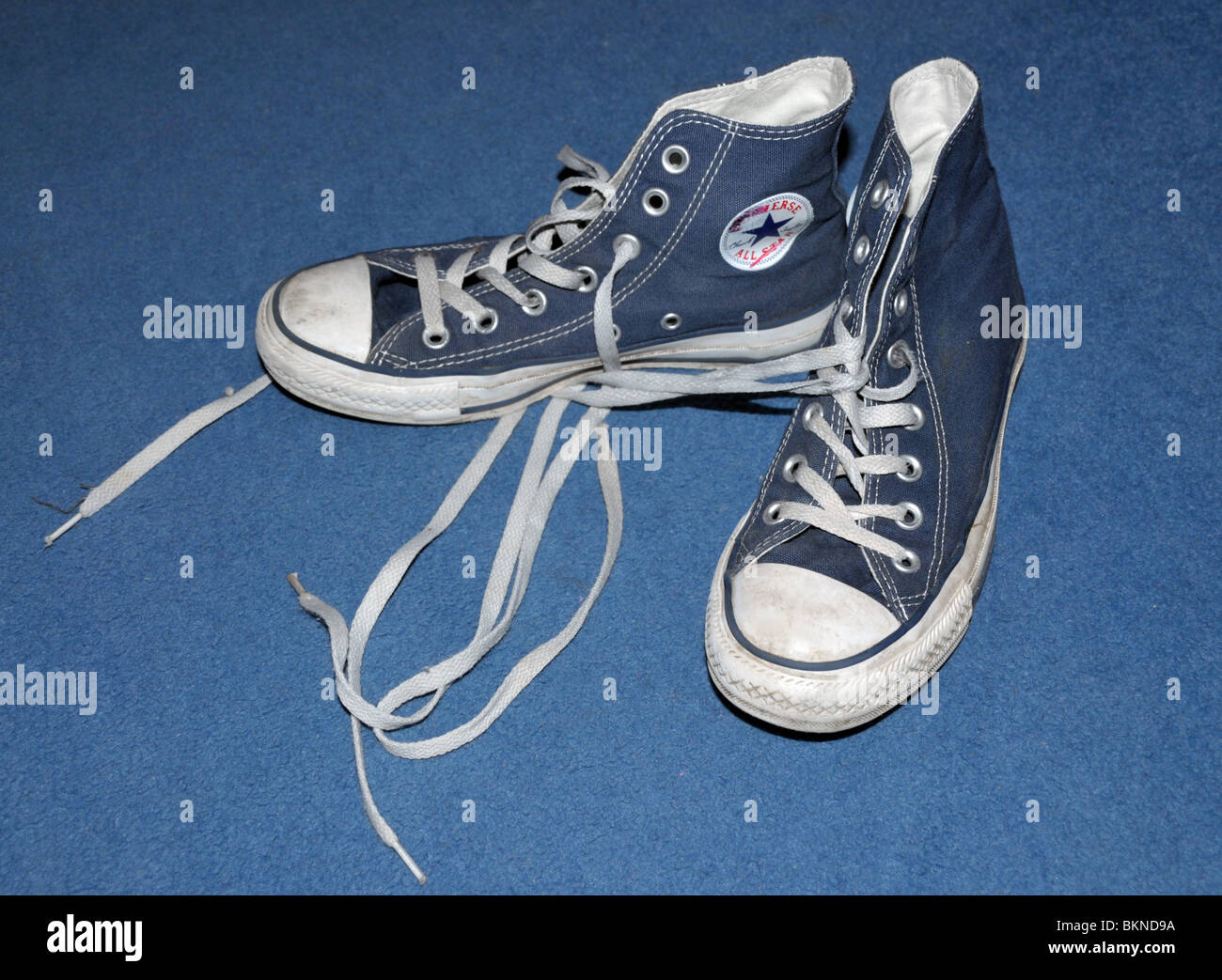 A pair of baseball / basketball trainers lying on a carpeted floor. Stock Photo