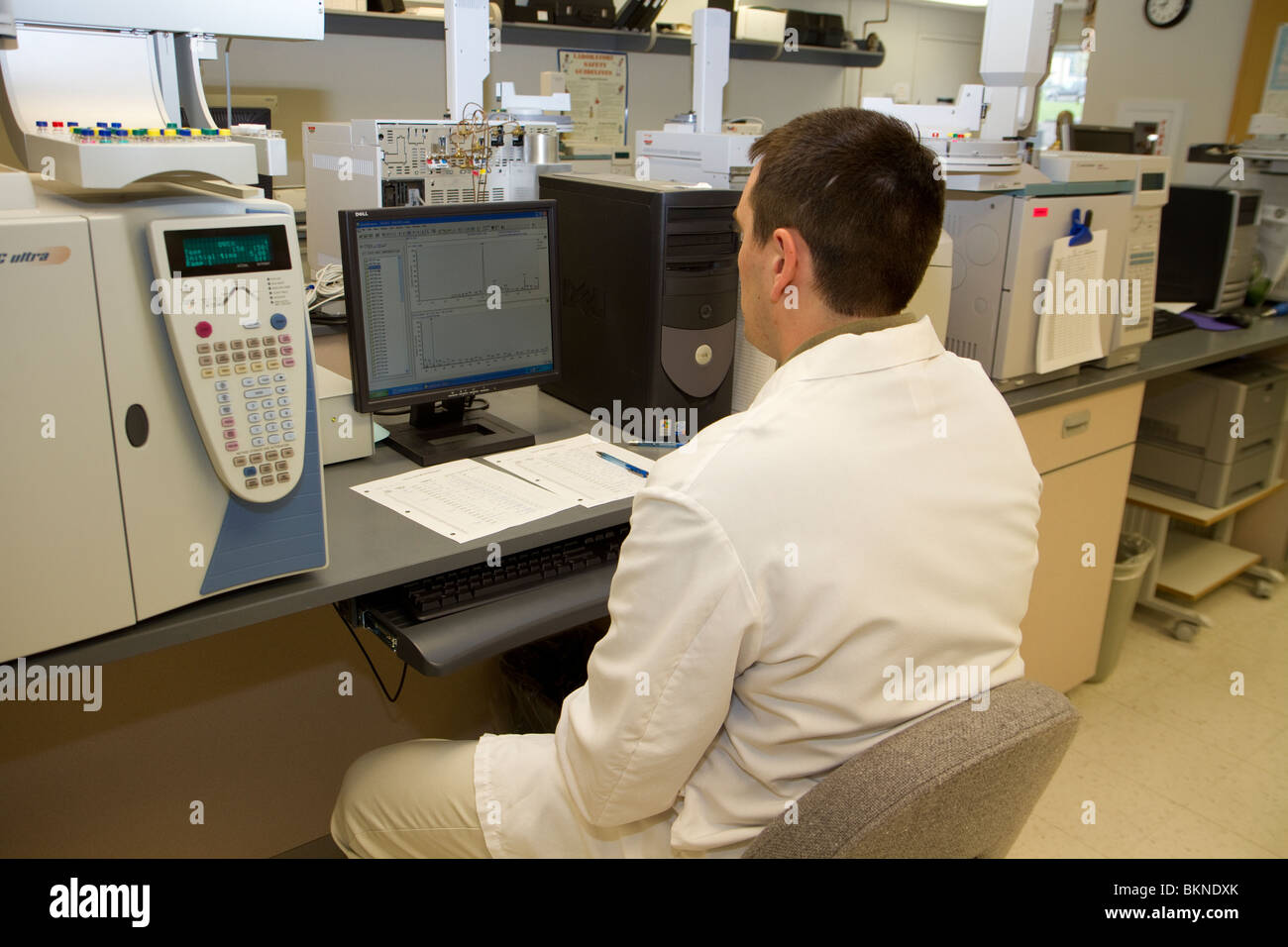 Forensic expert using gas chromatograph in forensic laboratory