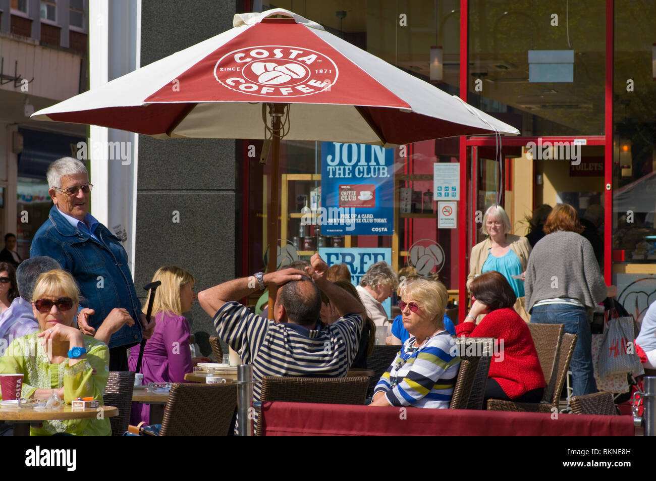 People Relaxing Together At Outside Tables Of A Costa Coffee Stock Photo