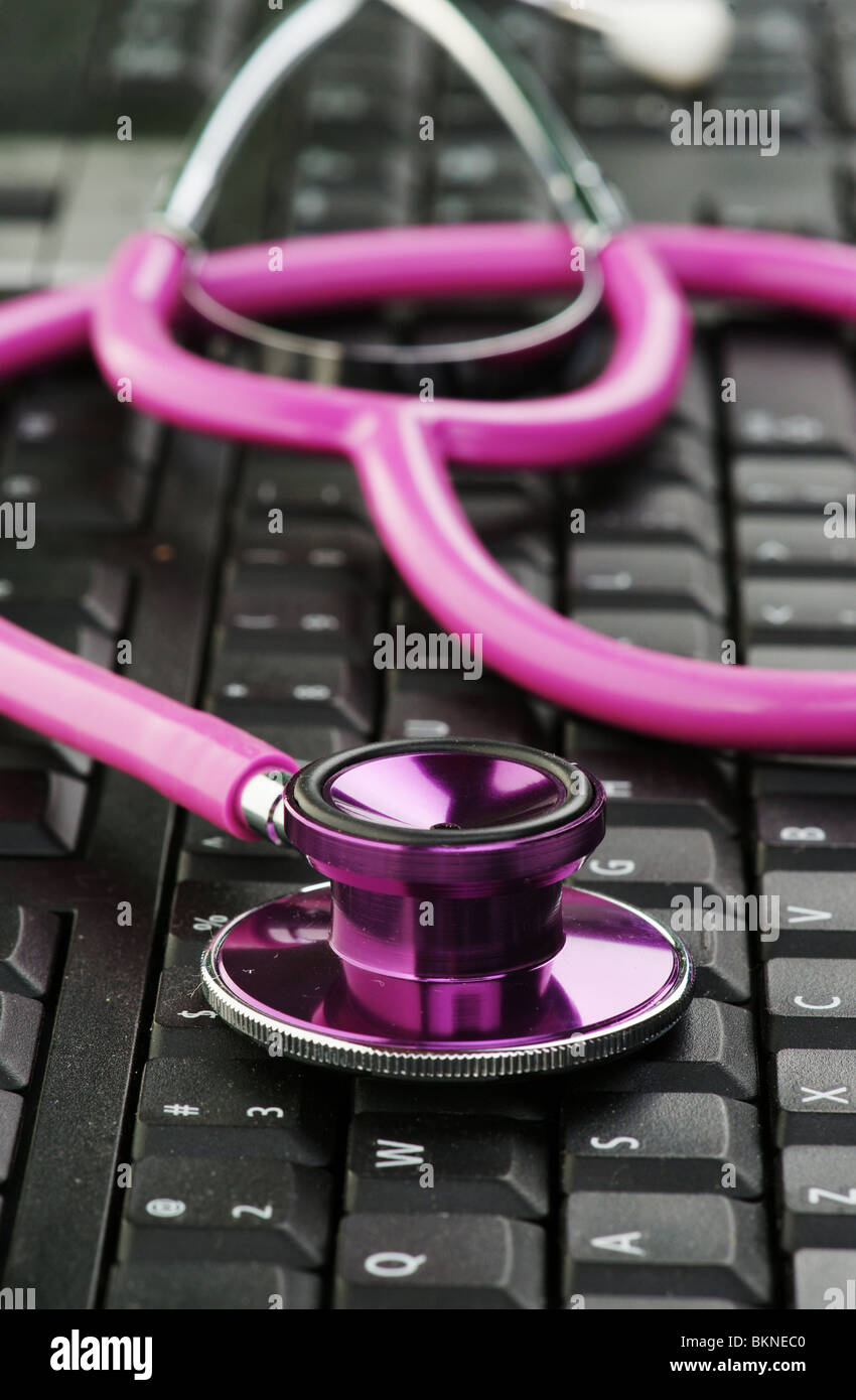 image of a pink stethoscope on a black keyboard Stock Photo