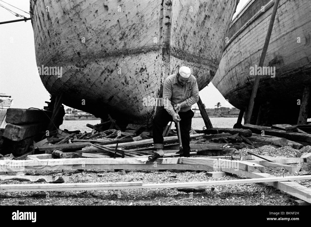A Man working in a boat yard in the Nile Delta town of Ra's al-Barr Stock Photo