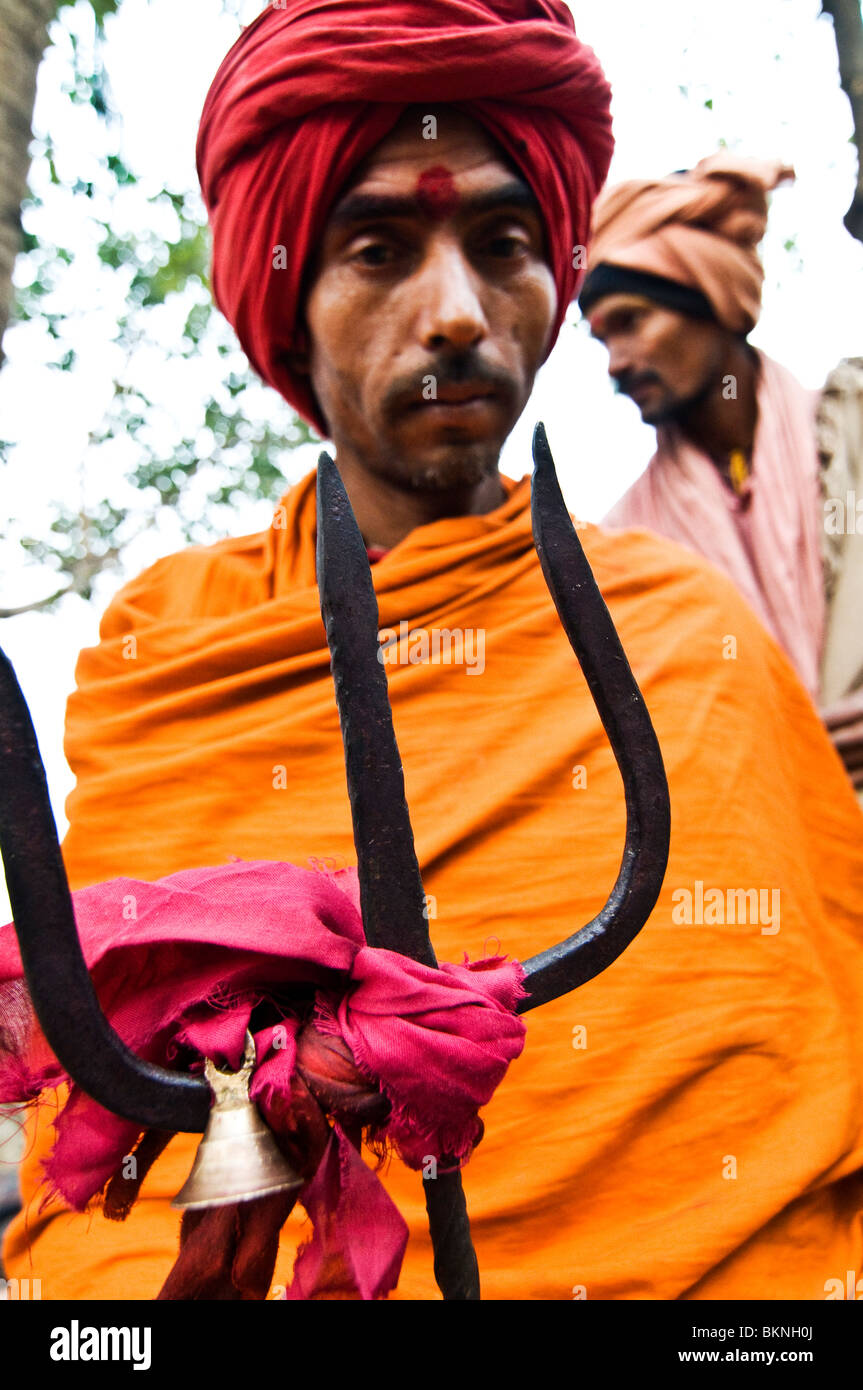 An Indian sadhu holding a trident which is the symbol of the god Shiva. Stock Photo