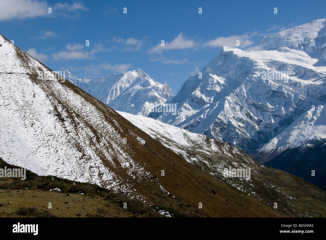 Snow clad mountains and high meadows, Yak Kharta, near Manang, Annapurna Circuit, Nepal Stock Photo