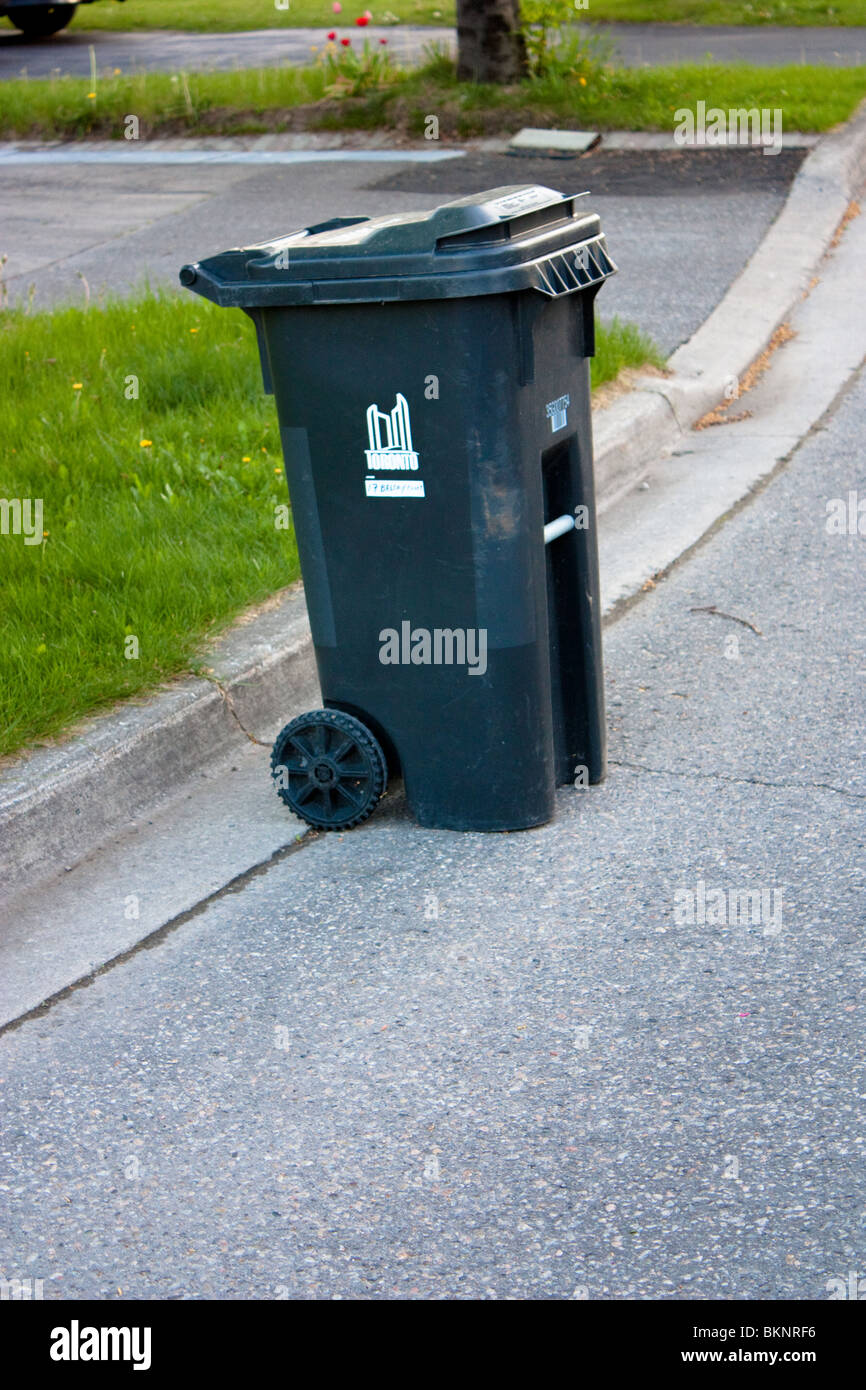 black garbage rubbish bin container household outside collection road street Stock Photo