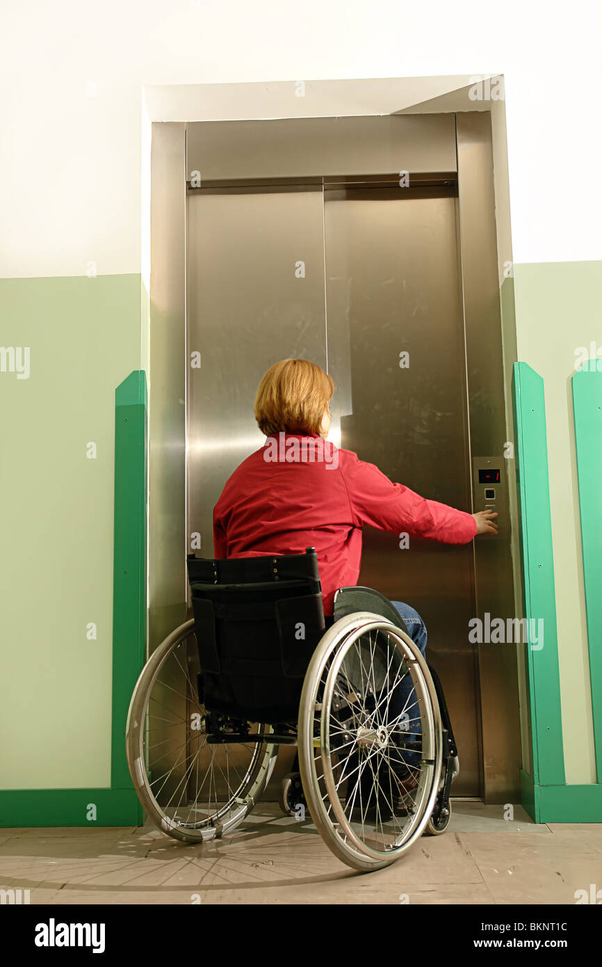 Wheelchair woman using elevator in building Stock Photo Alamy