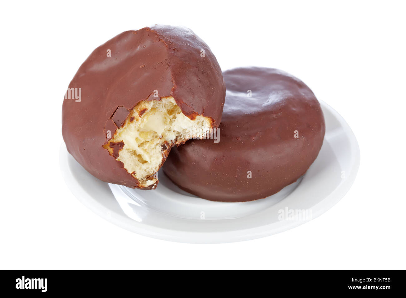 Two delicious chocolate donuts on a dish reflected on white background with shallow depth of field Stock Photo