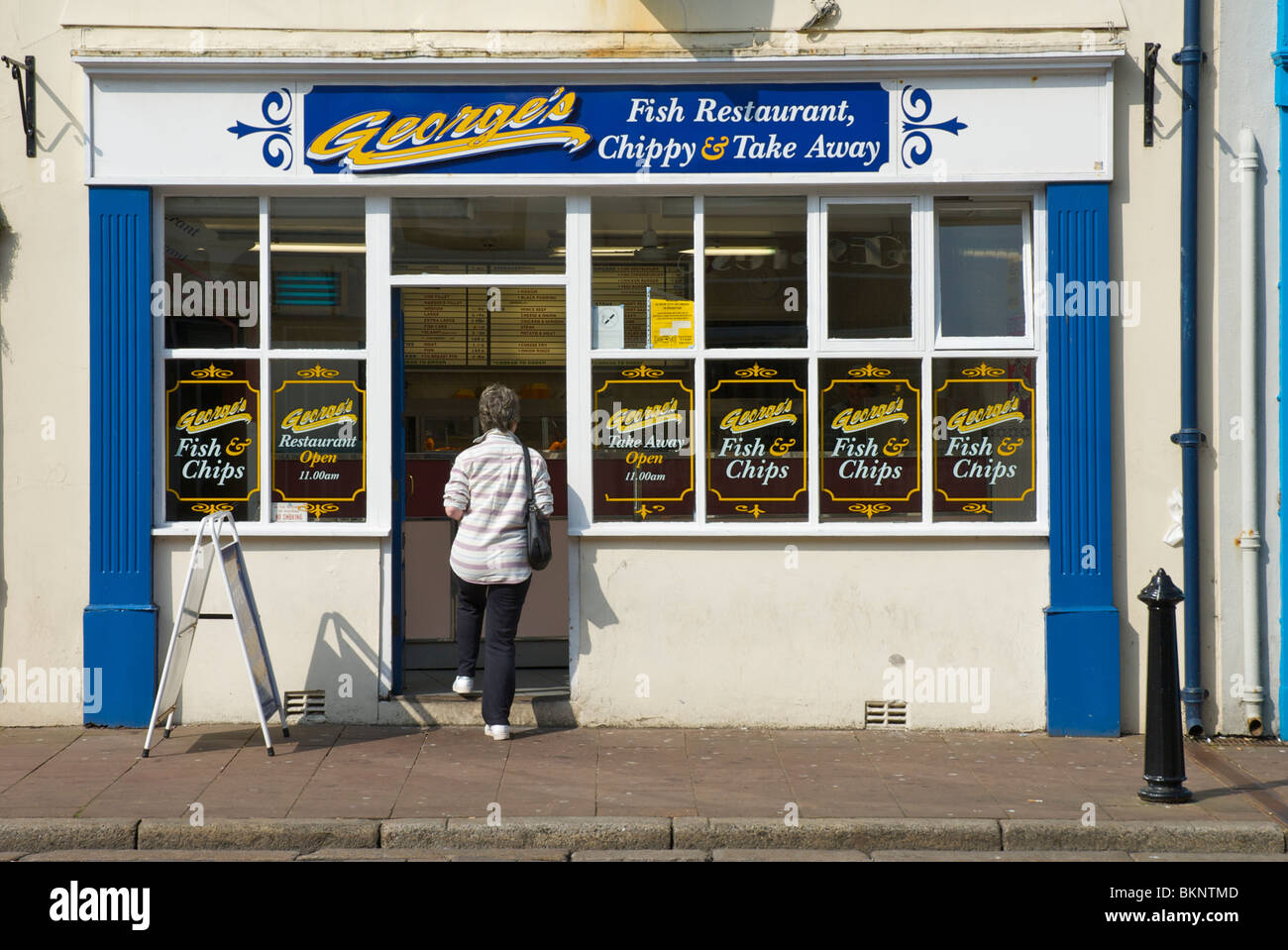 Woman walking into fish & chip shop, Whitehaven, West Cumbria, England uk Stock Photo