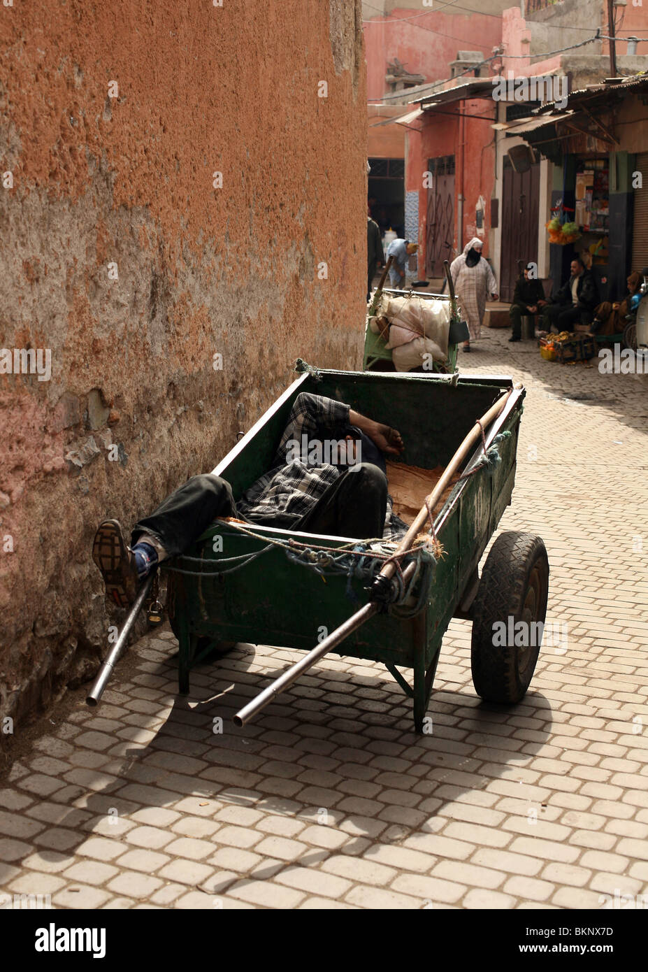 A Moroccan man is pictured asleep in his cart in the Souks of Marrakesh, Morocco Stock Photo