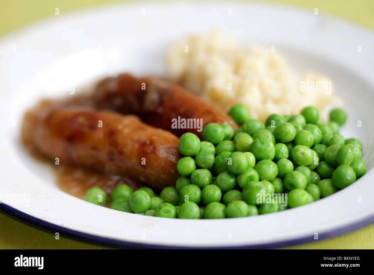Freshly Cooked And Prepared Meal Of Sausage And Mash With Peas and Gravy And No People Stock Photo
