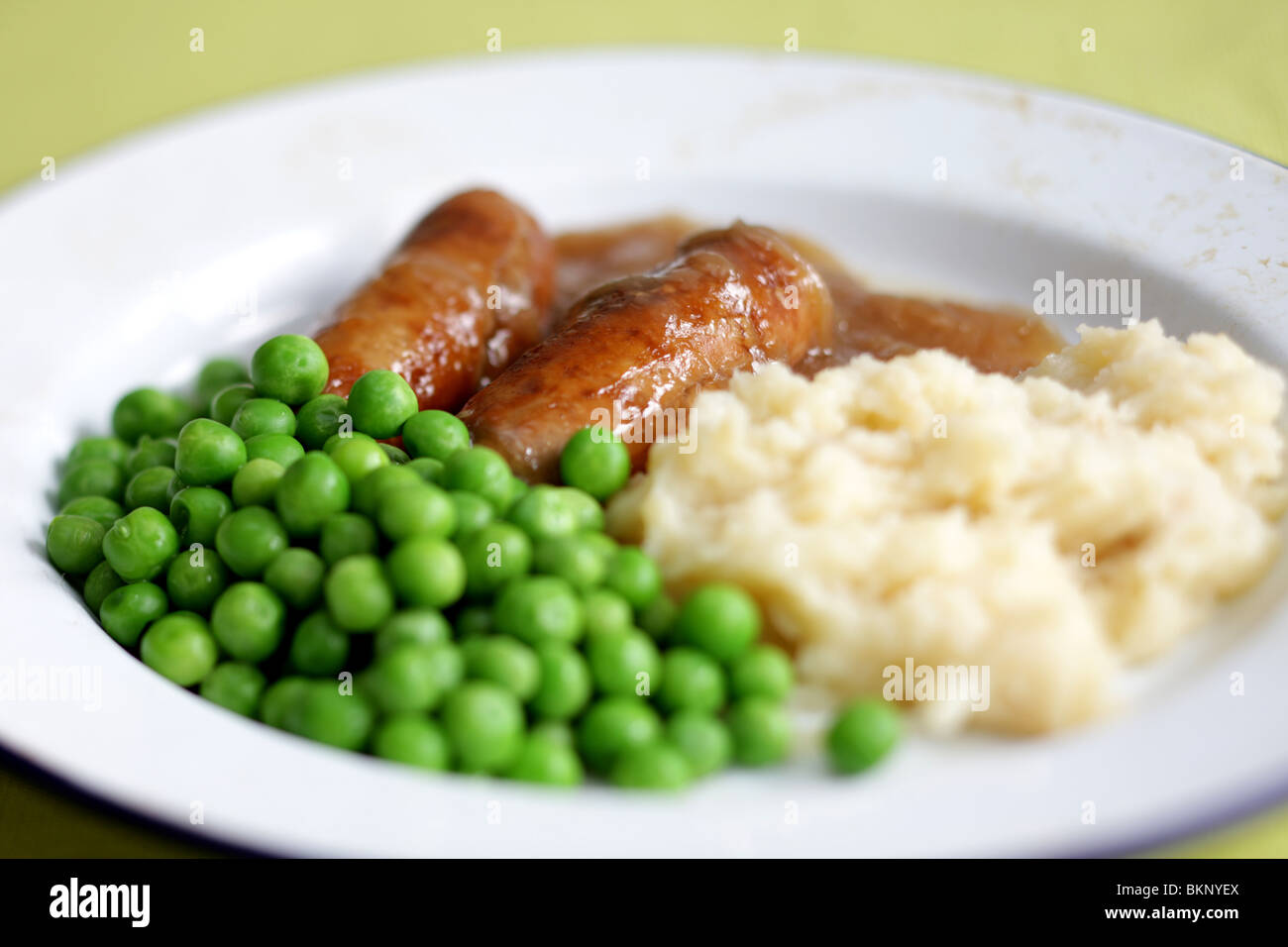 Freshly Cooked And Prepared Meal Of Sausage And Mash With Peas and Gravy And No People Stock Photo