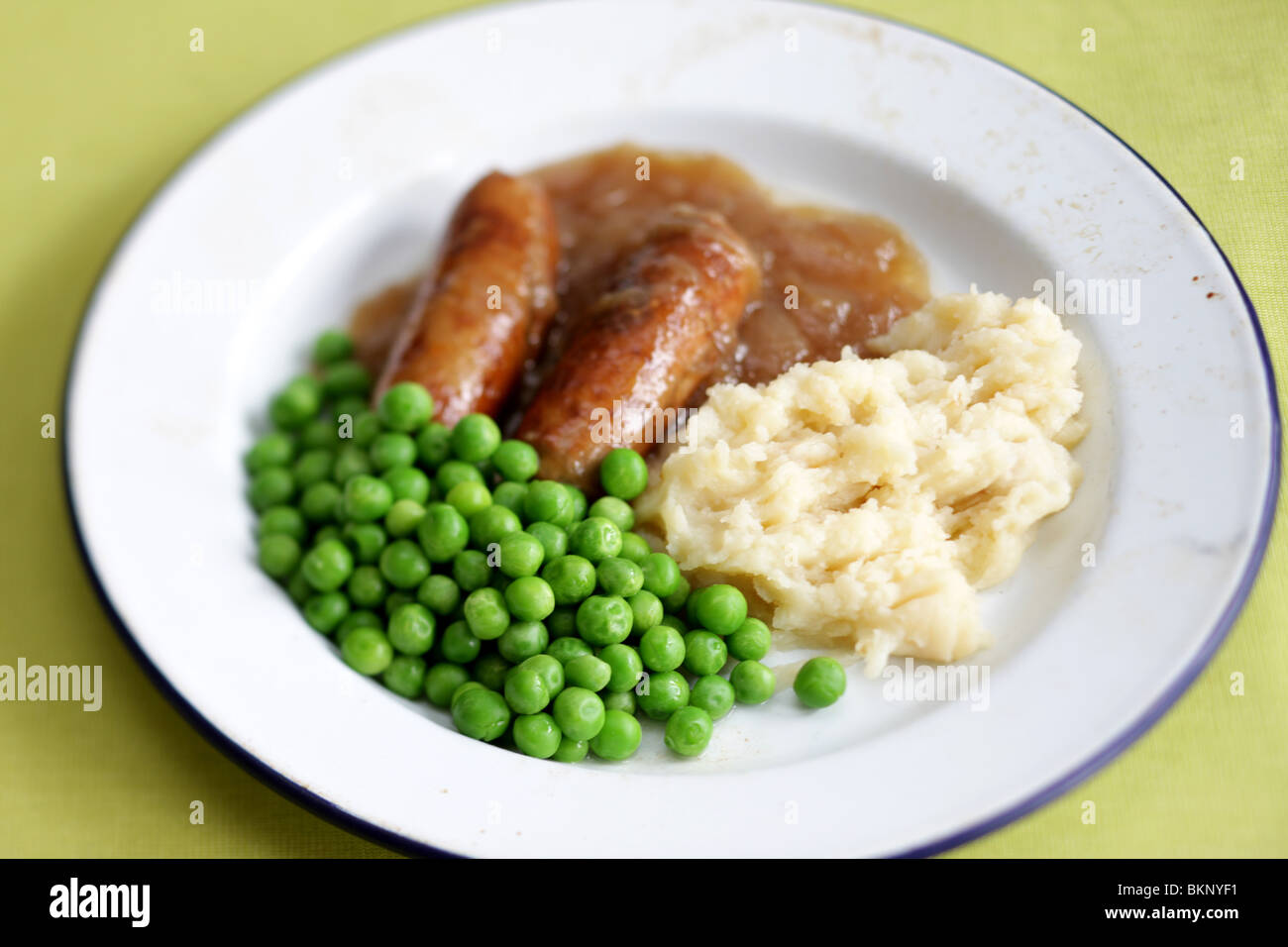 Freshly Cooked And Prepared Meal Of Sausage And Mash With Peas and Gravy And No People Stock Photo