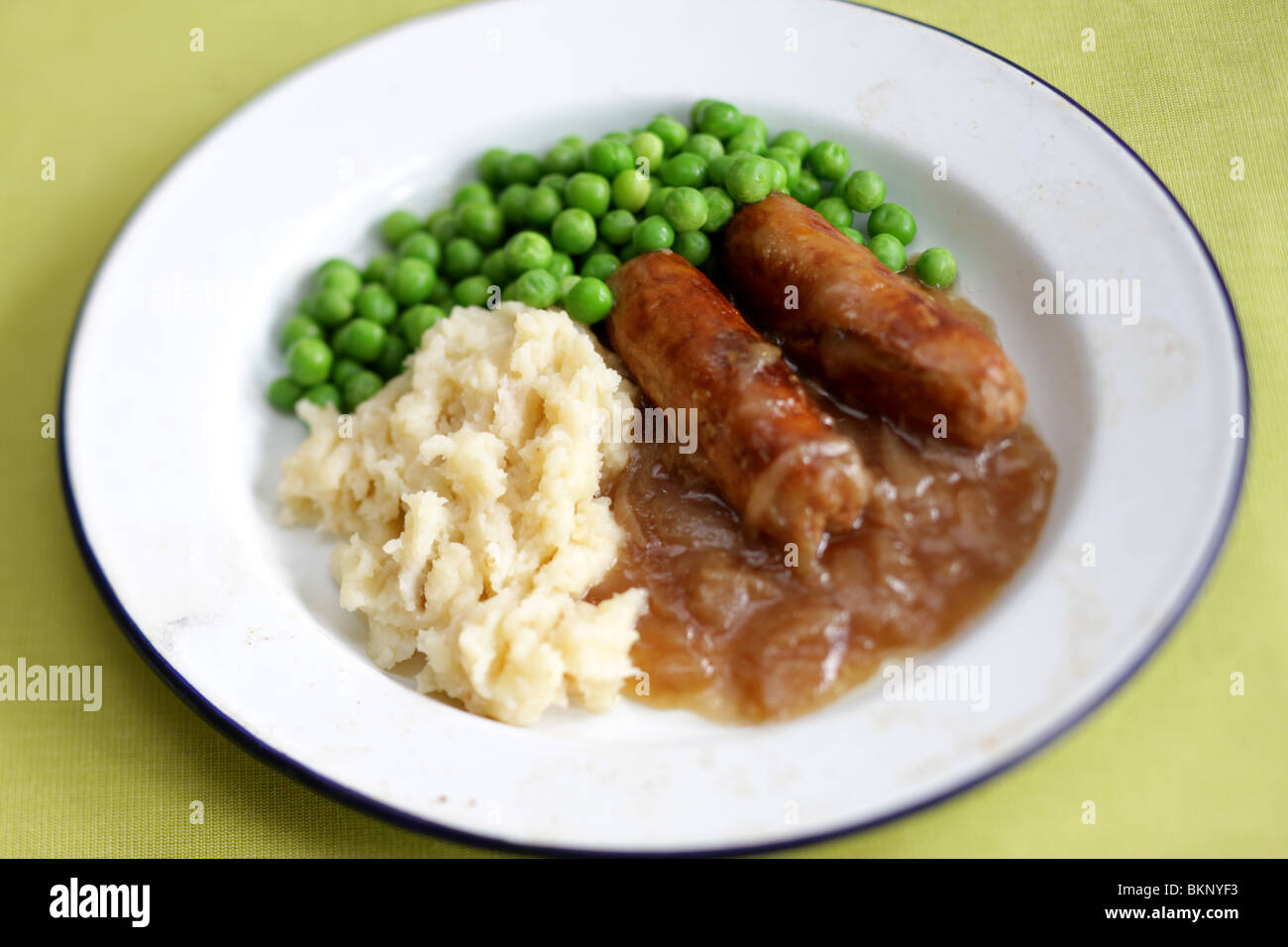 Freshly Cooked And Prepared Meal Of Sausage And Mash With Peas and Gravy And No People Stock Photo