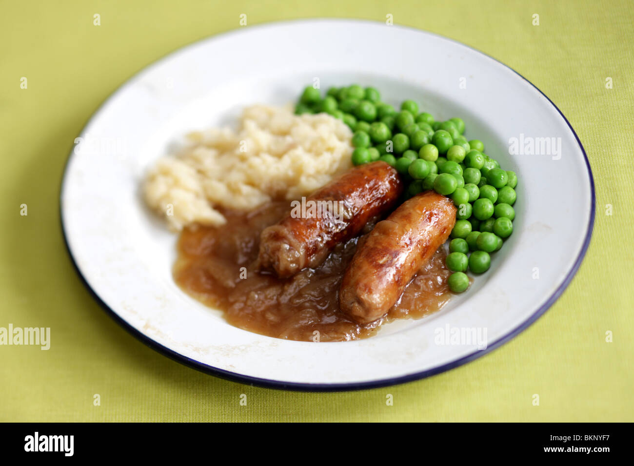 Freshly Cooked And Prepared Meal Of Sausage And Mash With Peas and Gravy And No People Stock Photo