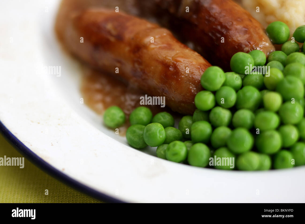 Freshly Cooked And Prepared Meal Of Sausage And Mash With Peas and Gravy And No People Stock Photo
