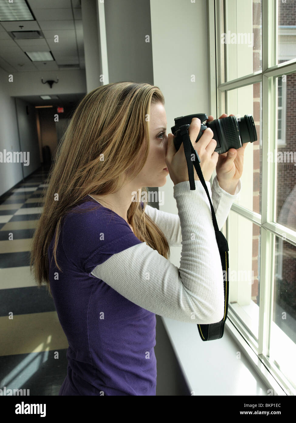female woman photographer taking photographs pictures using a black SLR digital camera action viewfinder Stock Photo