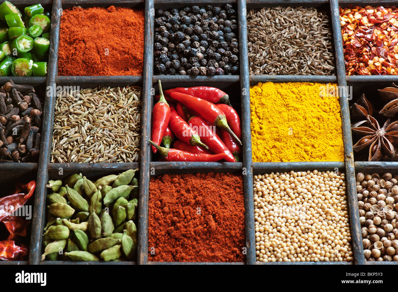 Indian cooking spices in an old wooden tray. Stock Photo