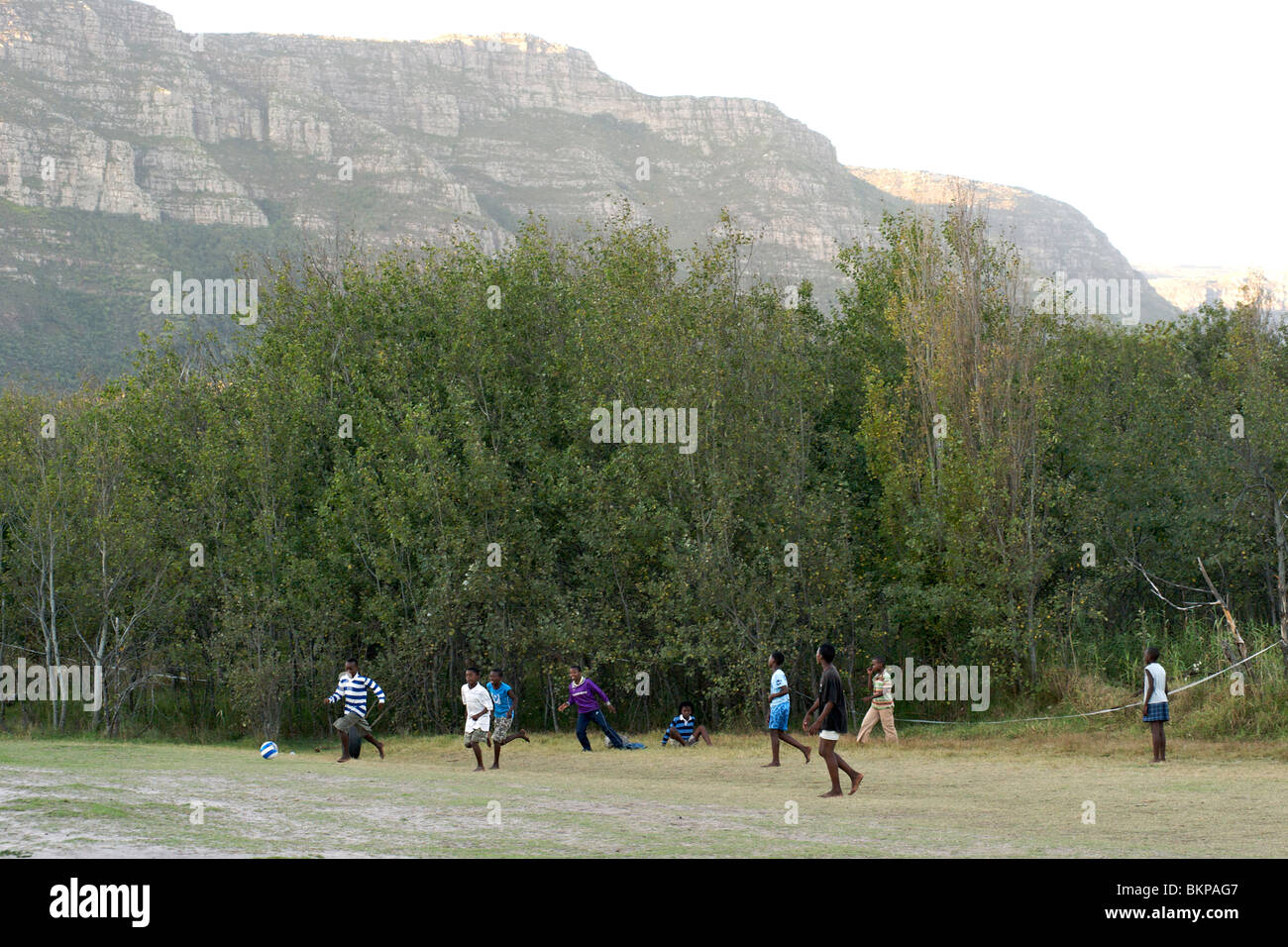 African children playing soccer barefoot in a field in Hout Bay in Cape