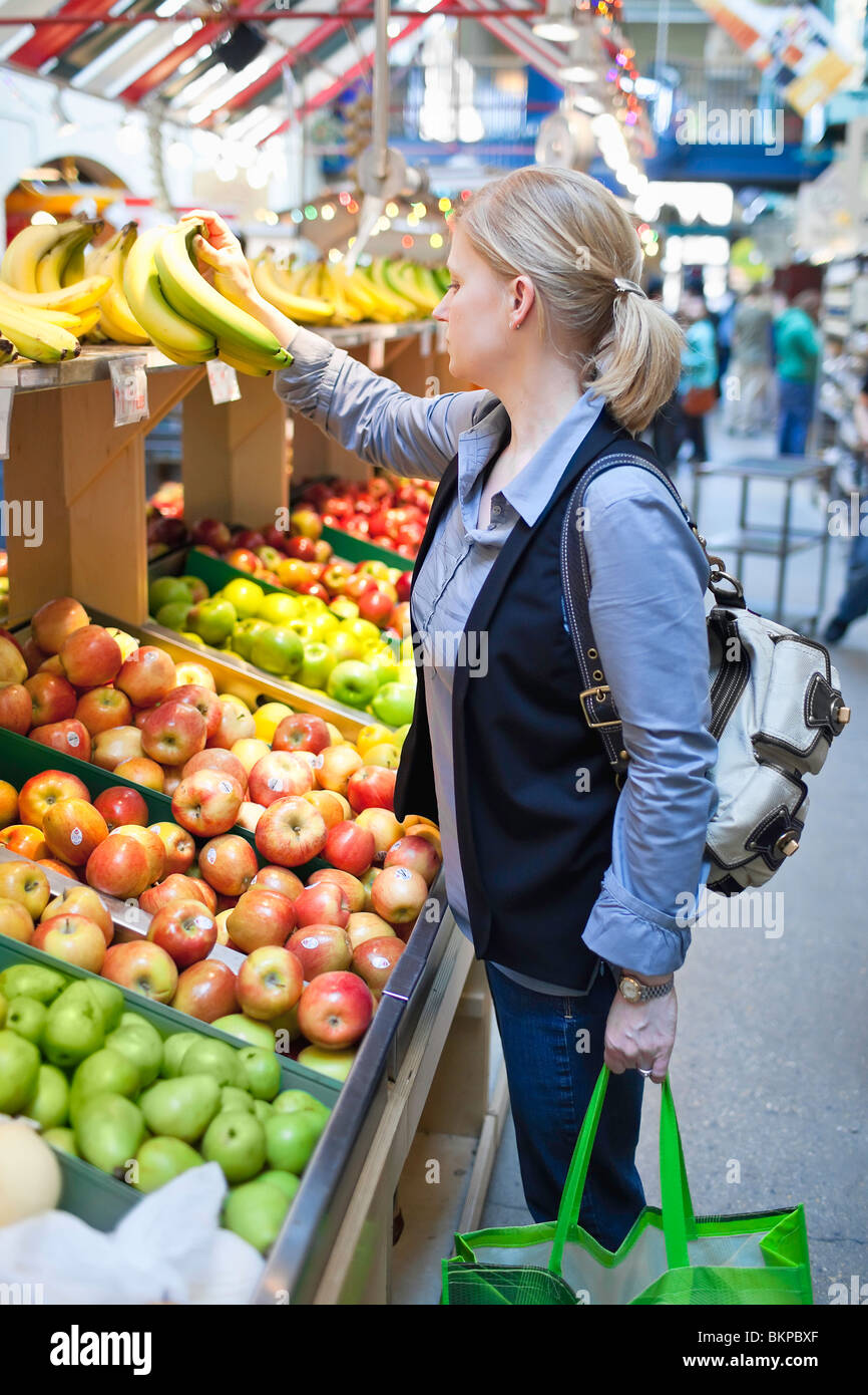 Woman shopping at an indoor produce market, The Forks Market, Winnipeg, Manitoba, Canada. Stock Photo