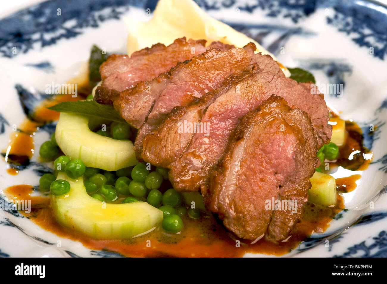 Karoo rump of lamb with mashed potato, garden peas, cucumber, mint and jus. Stock Photo