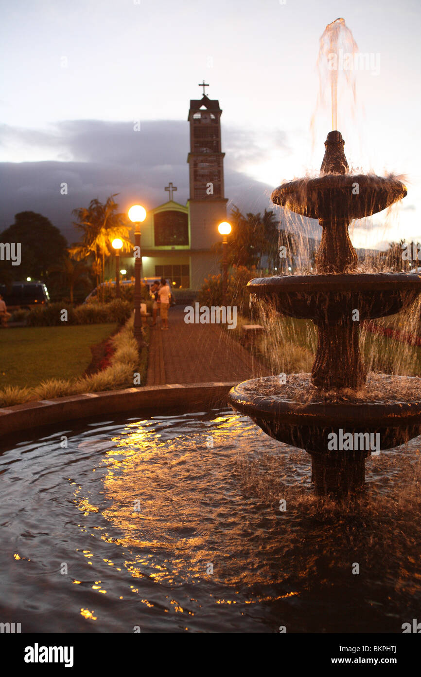 Central Park water fountain and La Fortuna Catholic Church at dusk