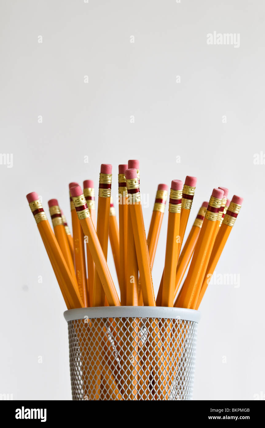Numerous orange HB lead pencils in holder on white background. Stock Photo