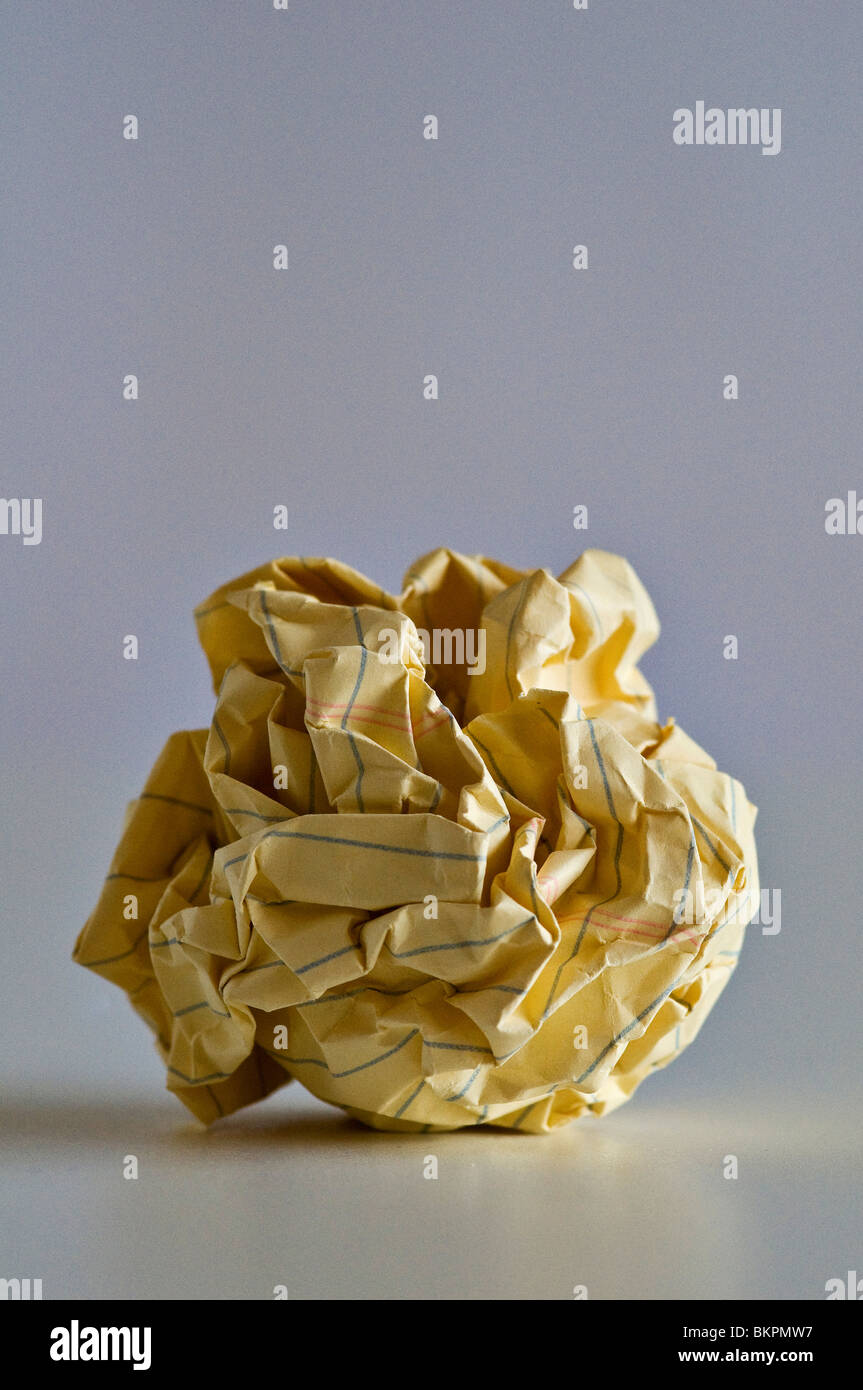 Crumpled yellow paper ball of failed ideas. Stock Photo