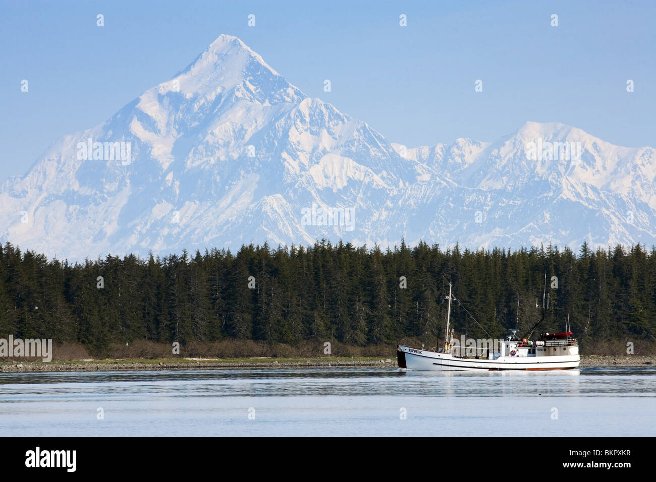 Scenic view of the St. Elias Range with a fishing schooner in the foreground near Yakutat, Alaska Stock Photo