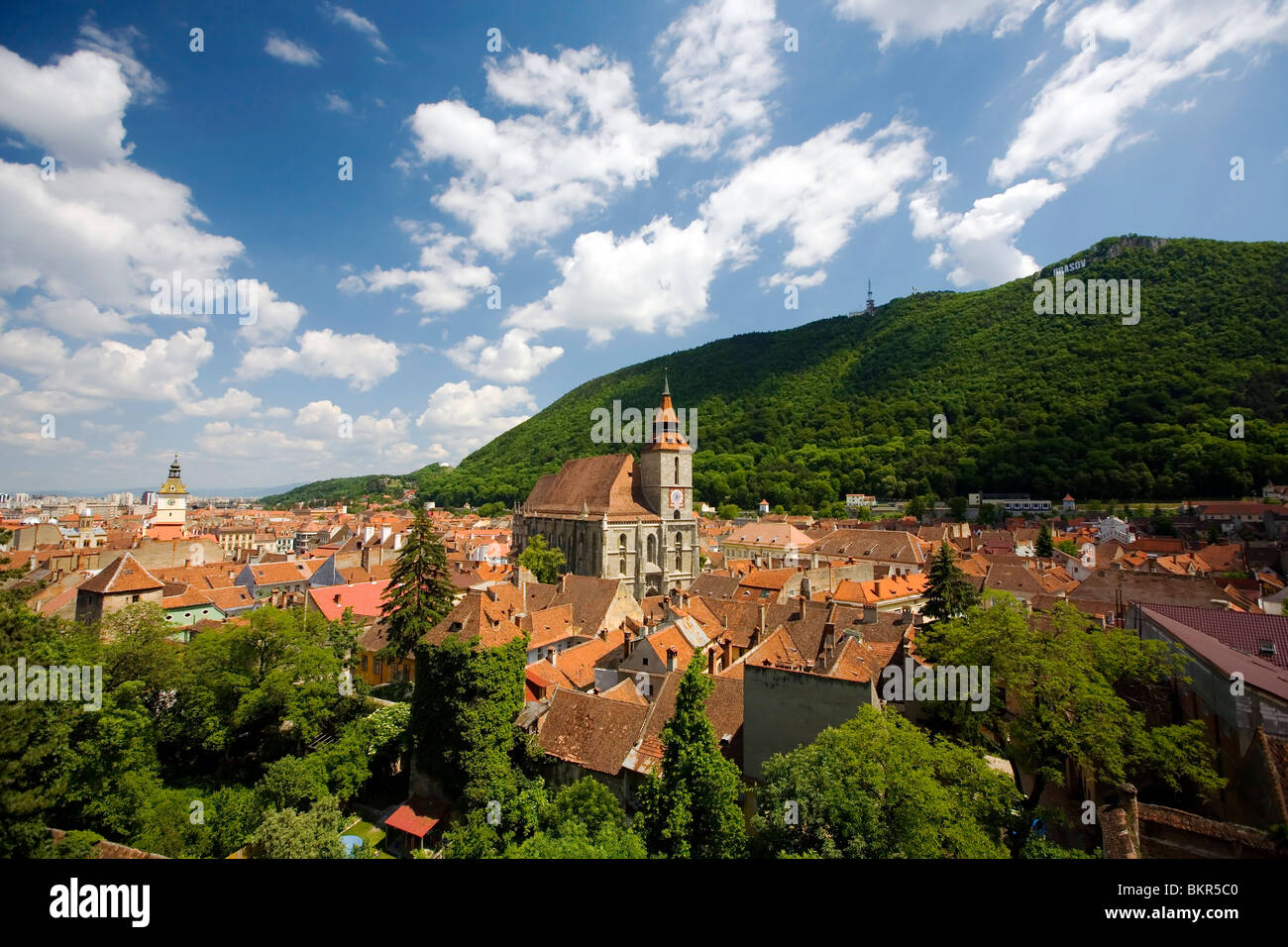 Romania, Transylvania, Brasov. Rooftops of the old centre of Brasov, surrounded by woodlands. Stock Photo